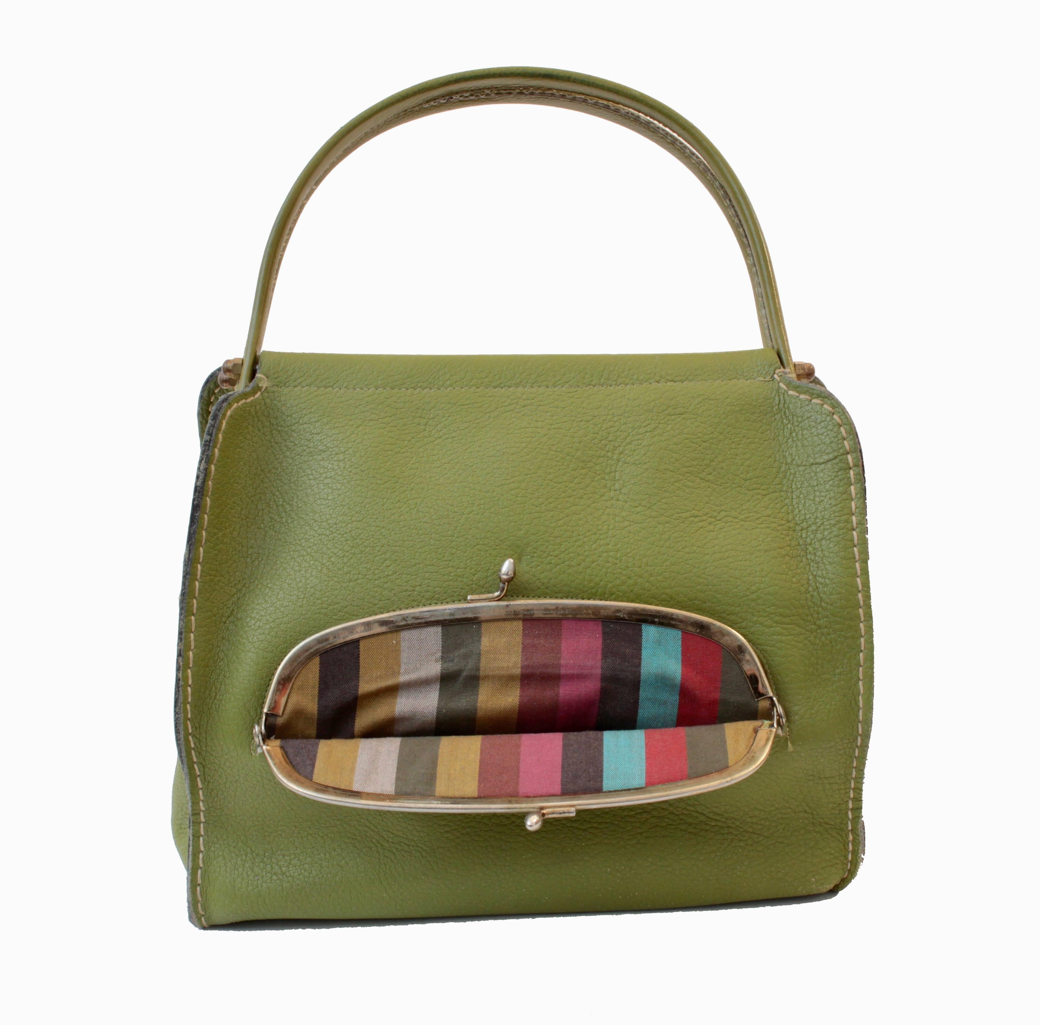 This cool little bag was designed by Bonnie Cashin during her time at Coach Leatherware in the 1960s.  Made from lime green leather, it features a large brass kiss lock coin purse in front, and double leather covered handles.  Inside is lined in