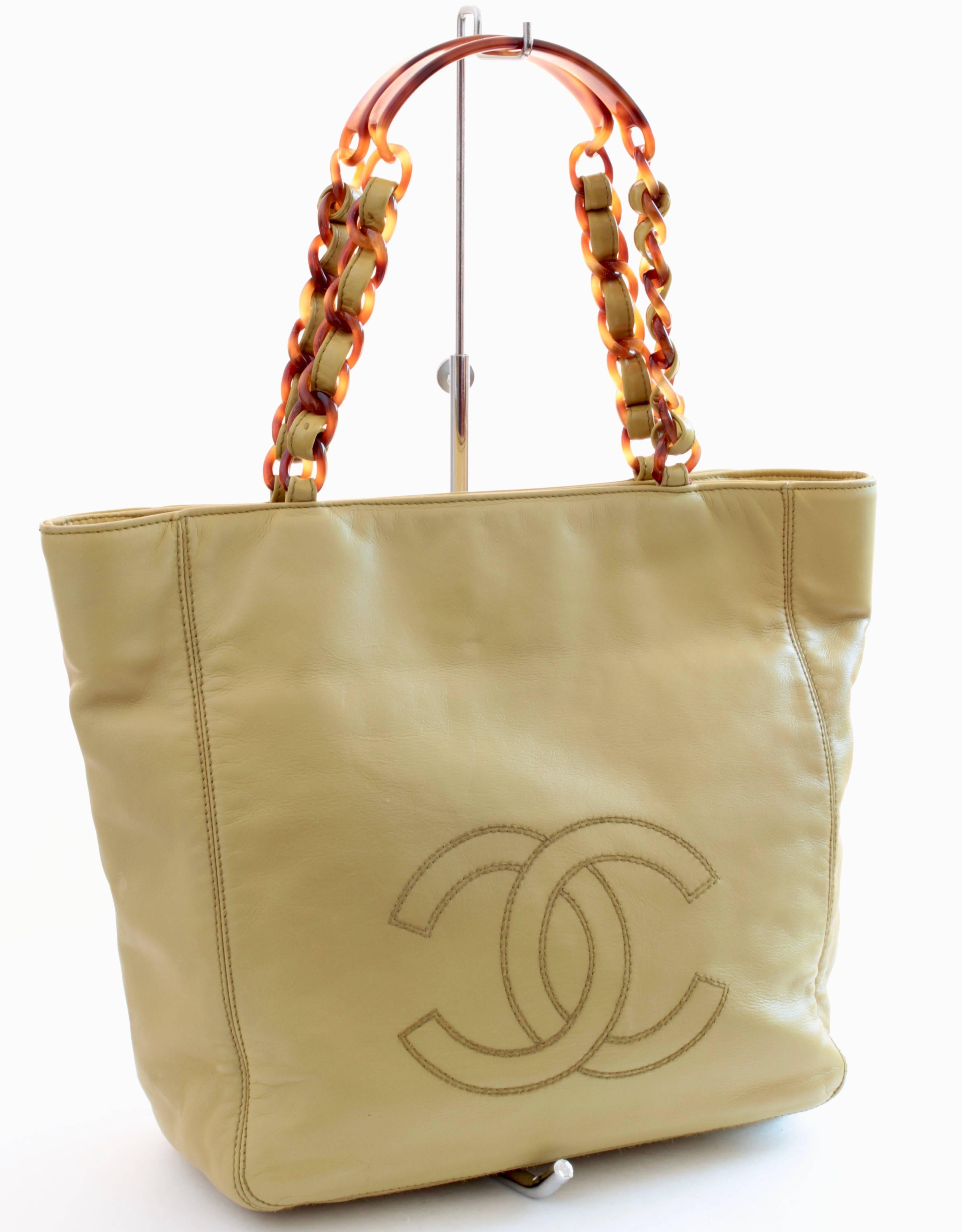 This chic tote bag was made by Chanel, most likely in the late 1990s.  Made from smooth Chartreuse leather, it features faux tortoise chain straps and fastens with magnetic clasps.  The interior is lined in matching fabric and has a zippered pocket.