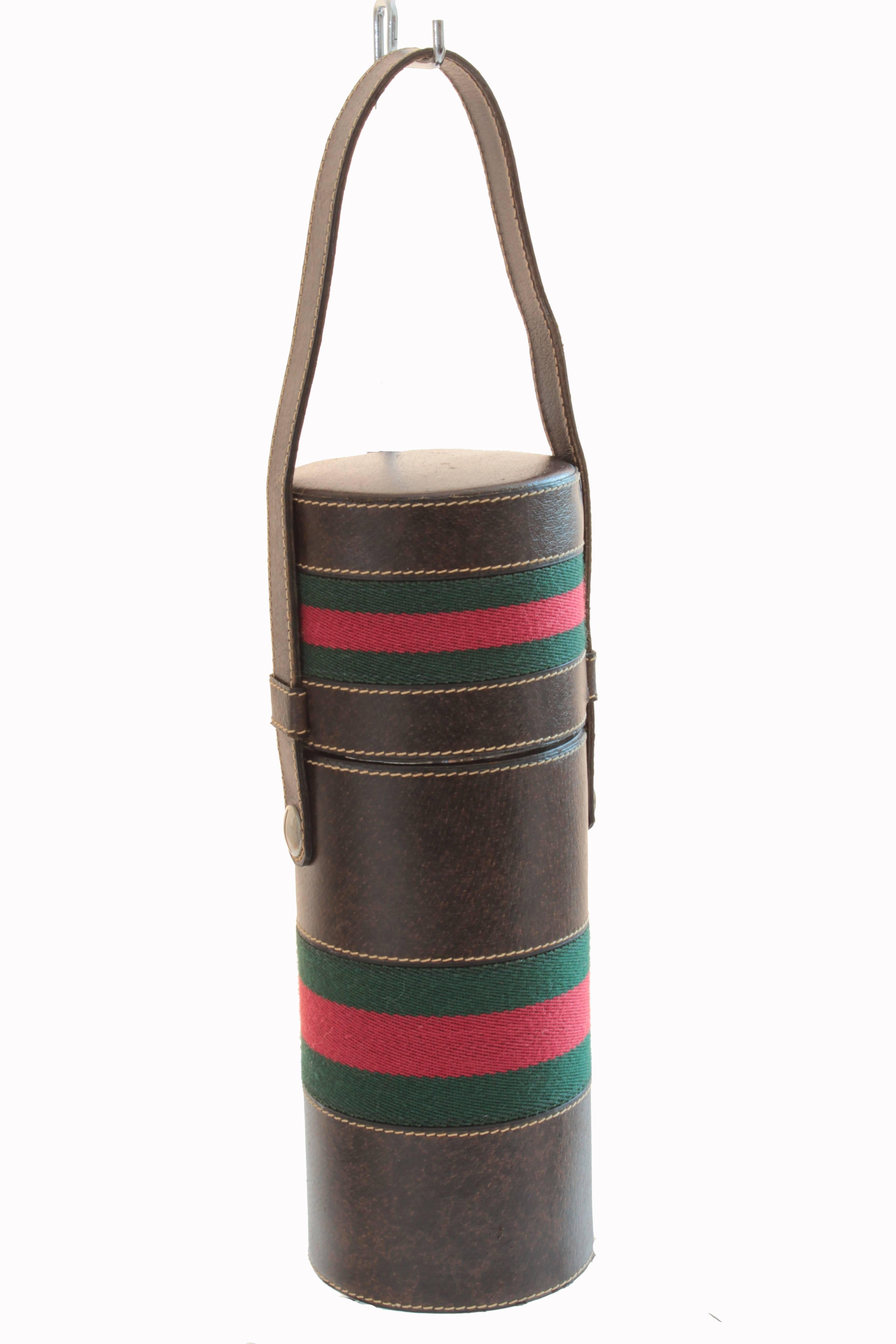 This ultra rare thermos cover tote was made by Gucci, most likely in the early 1970s.  Made from brown leather, it features Gucci's iconic red and green webbing and opens to reveal a steel flask with glass thermos bottle and cup.  In excellent