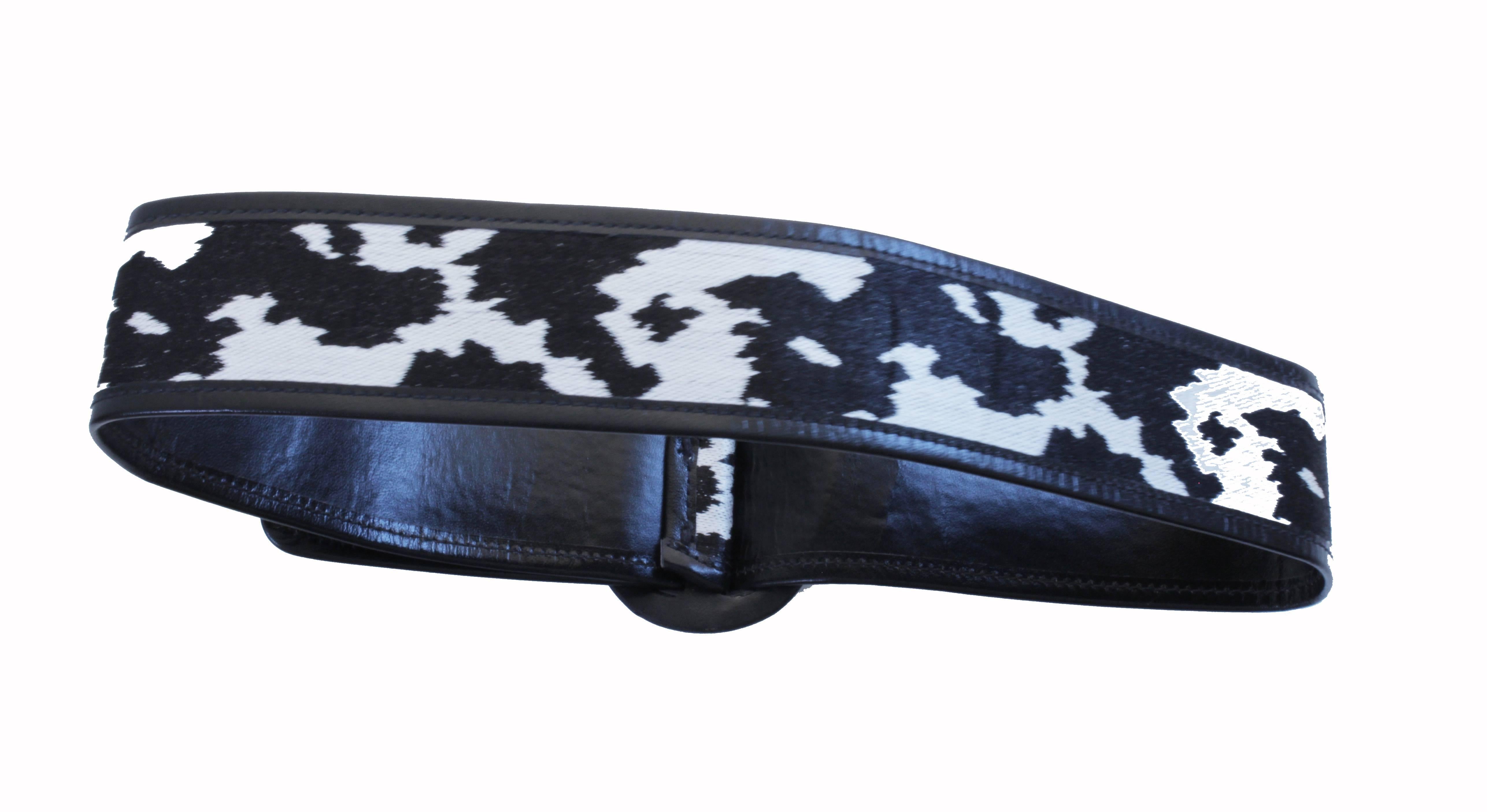 Here's a cool belt from Yves Saint Laurent! It features a black & white abstract print over black leather (reminds us of an abstract cow print!).  No size stamp, but best fits between a 23in - 26in waist and is 2in H.  Stamped Yves Saint Laurent. 