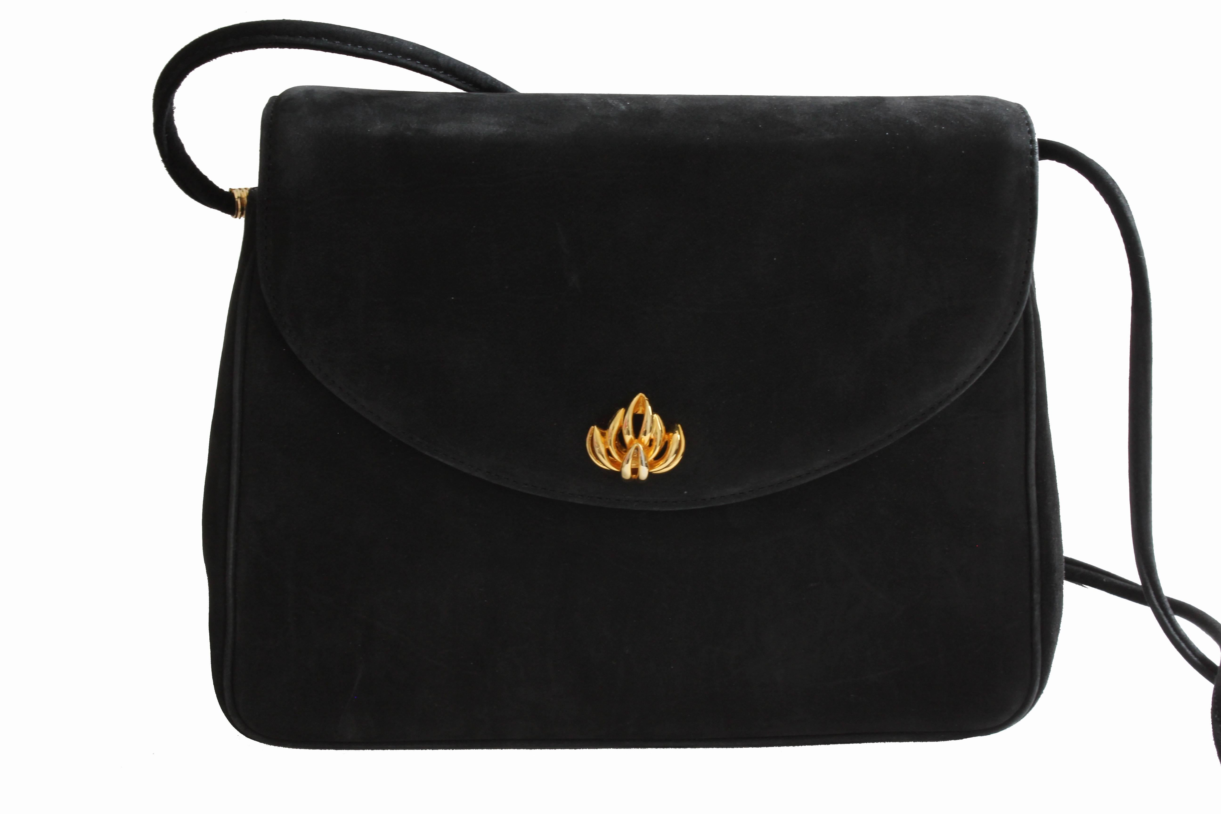 This classic handbag was made by Asprey London, most likely in the mid 1970s.  Made from black suede leather, it features a top flap, a hidden magnetic fastener and a removable shoulder strap for wear as a clutch or as a shoulder bag.  Lined in