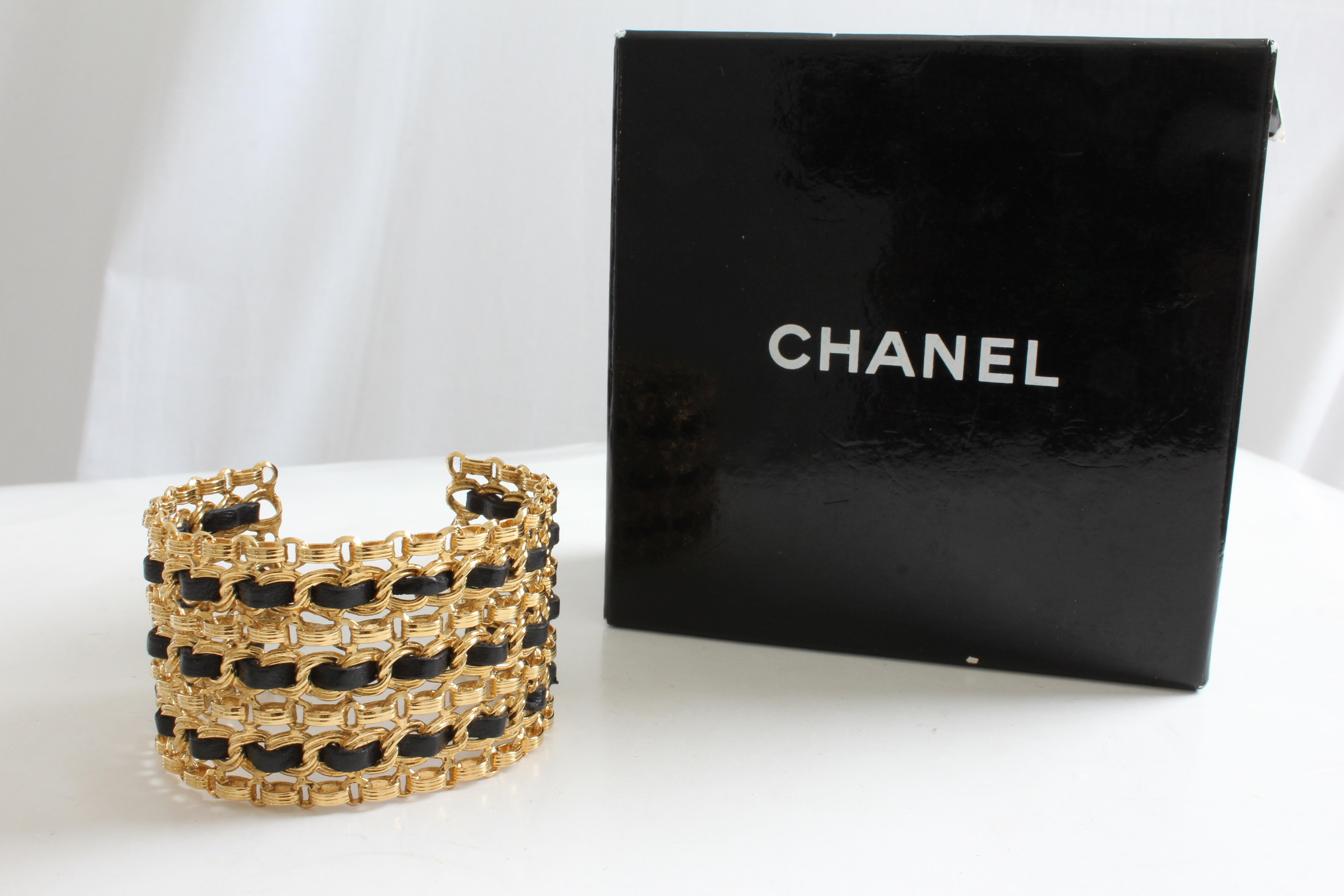 This fabulous wide cuff bracelet was made by Chanel, likely in the late 70s or early 1980s, Made from gold metal chains, it features black leather strips interwoven throughout. In very good preowned condition given its age with minimal signs of