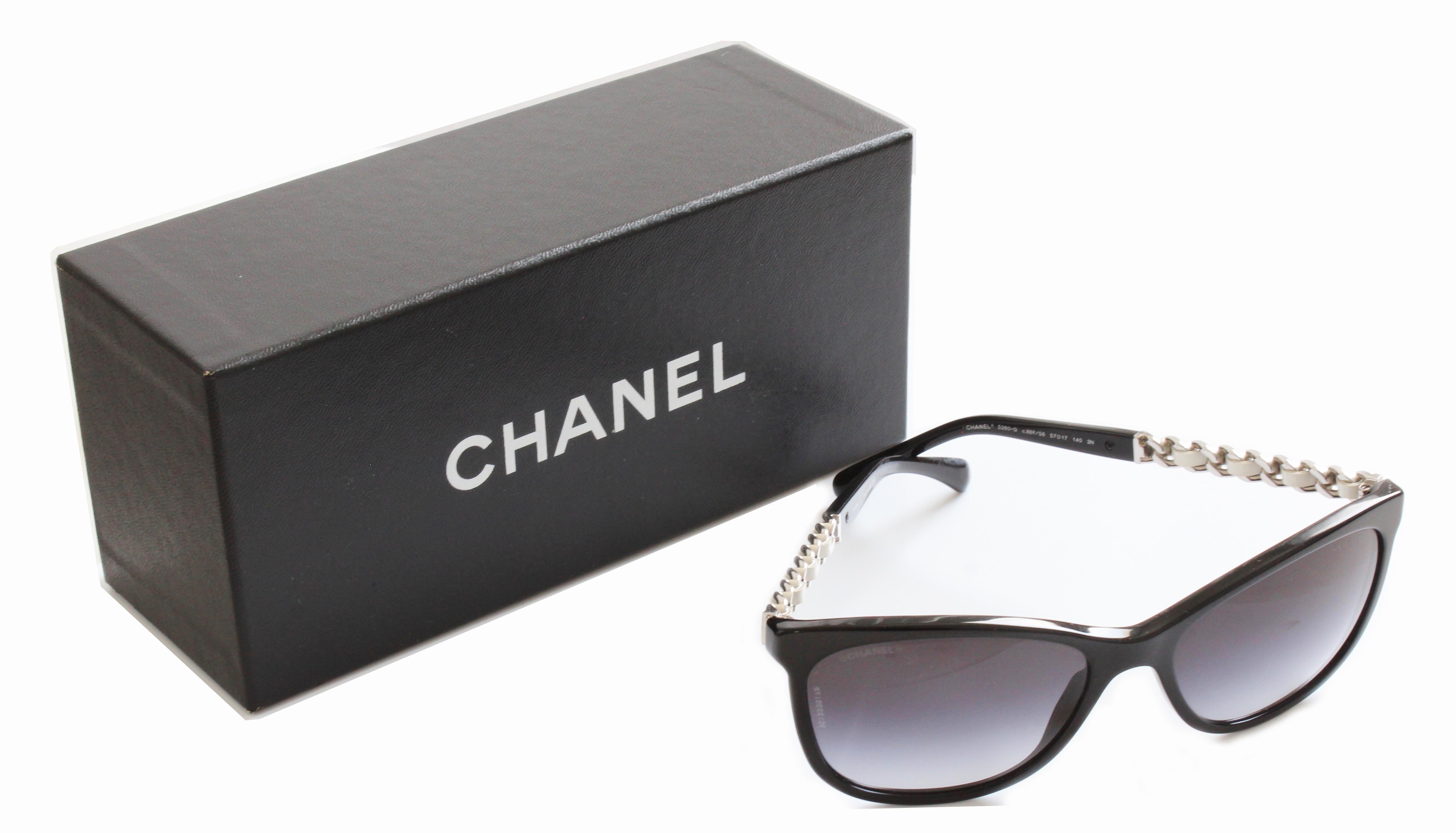 Here's a pair of authentic sunglasses from Chanel.  Stamped as model number 5260-Q c.888/S6, these cat eye style glasses feature silver chain and white leather arms and black gradient to gray lenses.  Comes with their original Chanel eye glass case,