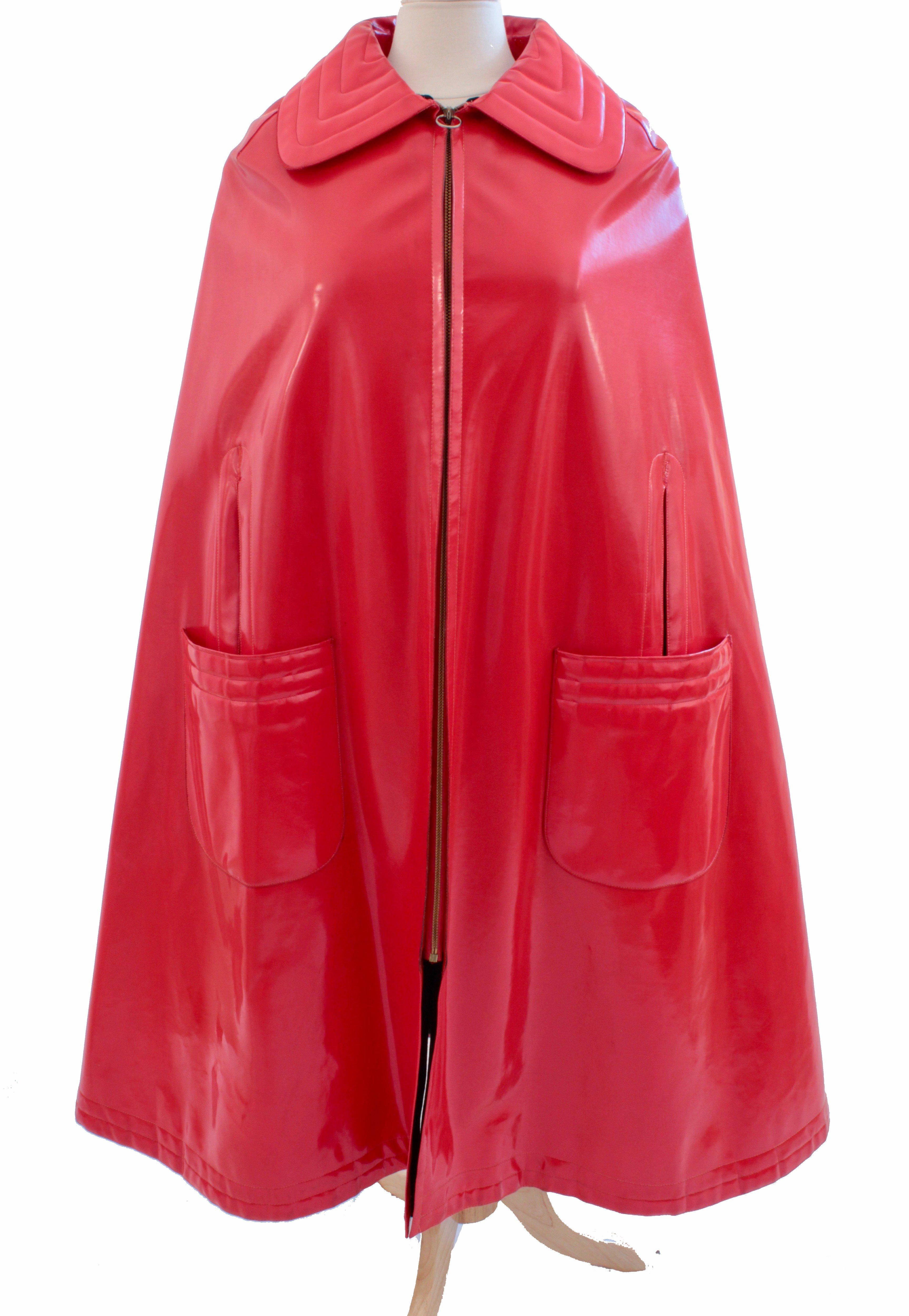 This fabulous space age cape was made by Pierre Cardin for his Space Age and Futurism Collection in the late 60s. Made from a soft red vinyl, it features quilted stitching at the collar and on each front pocket, and a rear vent.  It fastens with a