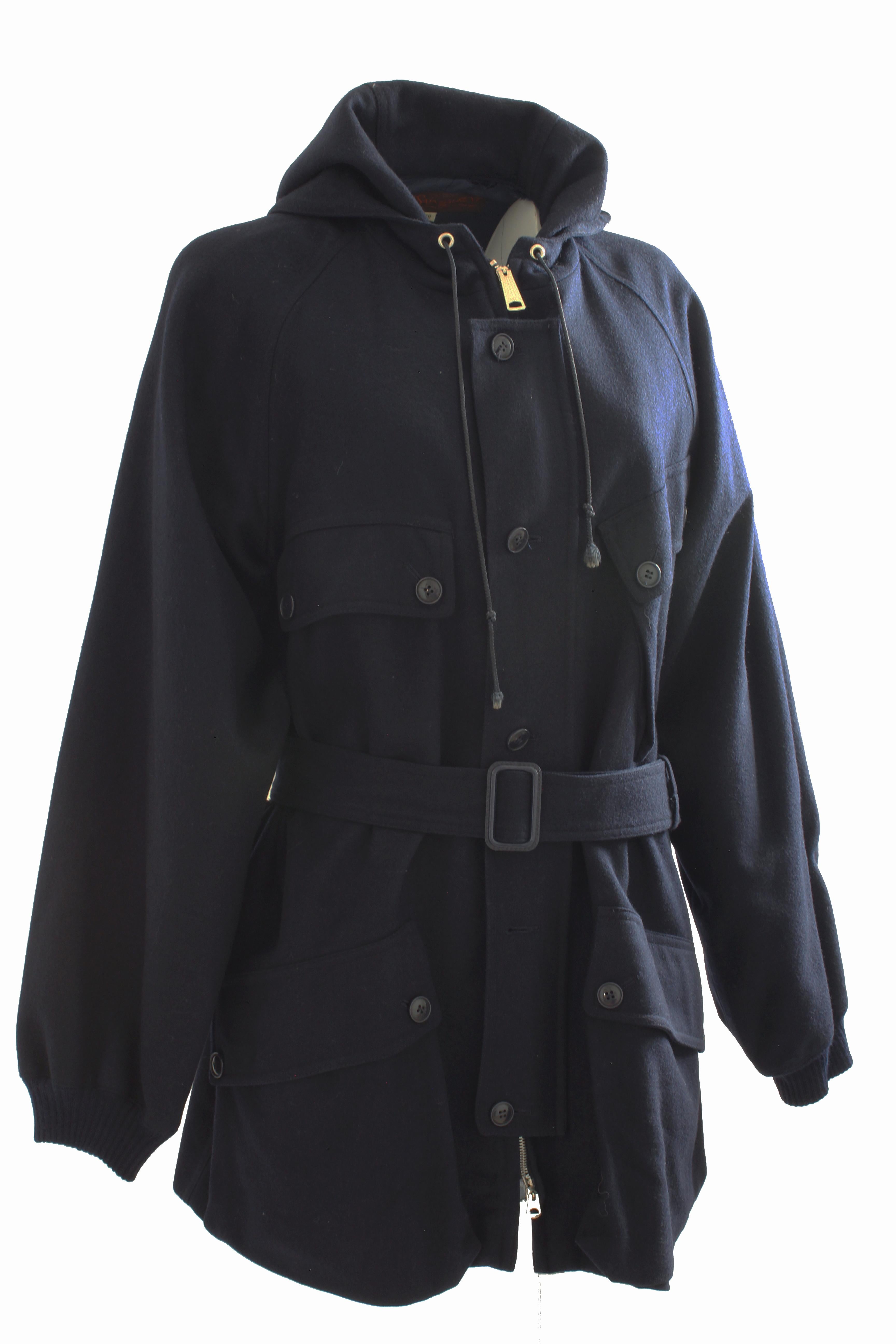 This classic hooded coat with belt was made by Yves Saint Laurent, most likely in the late 1970s. Made from navy wool, it features a metal zipper with a buttoned flap over the placket, four pockets and knit sleeve ends to protect against the