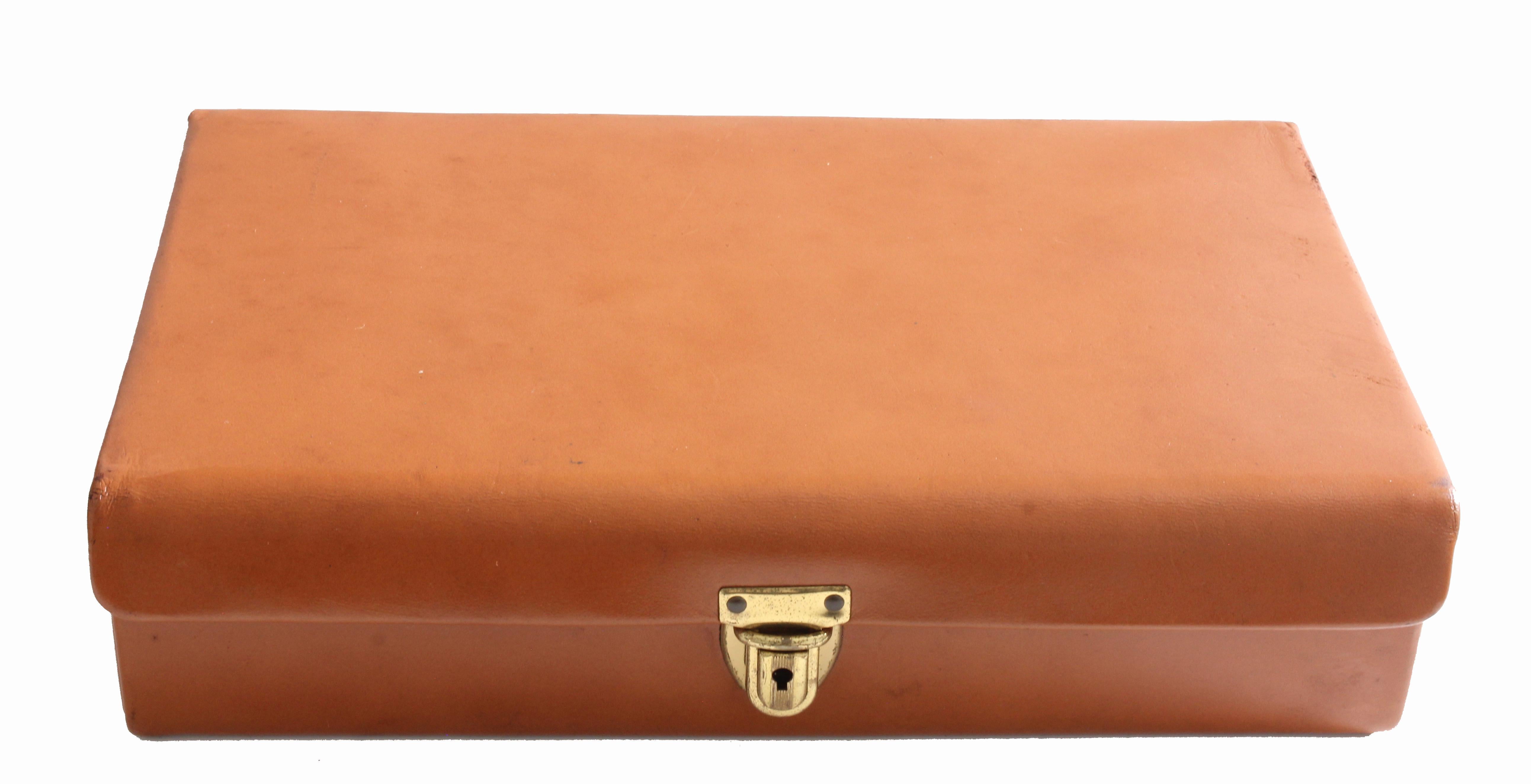 This leather jewelry case was likely made in the 1970s, and features a push lock fastener with key.  The interior is lined in suede and features a ring holder, a sueded pillow and compartment and a leather strap chain or bracelet holder on it's