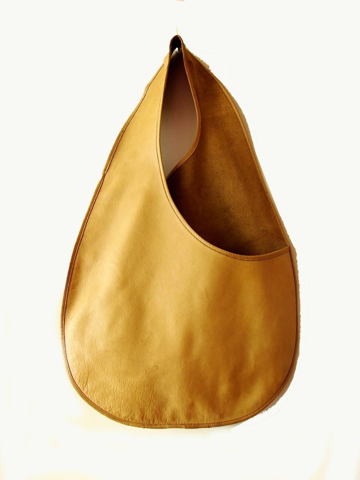 This mod sling bag was designed by Bonnie Cashin during her time at Coach Leatherware circa mid 1960s.   According to an article in ELLE magazine from 2011, FIT has one of these bags in their museum collection, and I believe another lives within the