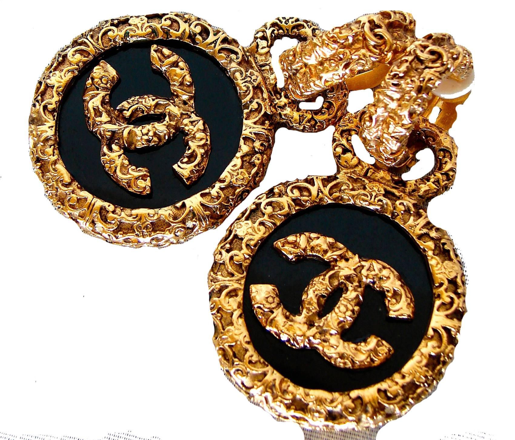 These impressive earrings were designed by Victoire de Castellane for Chanel as part of the 93A collection.  Each earring features two pieces: a gild metal clip earring with a tiny CC logo and a large gilt-trimmed black medallion with the iconic CC