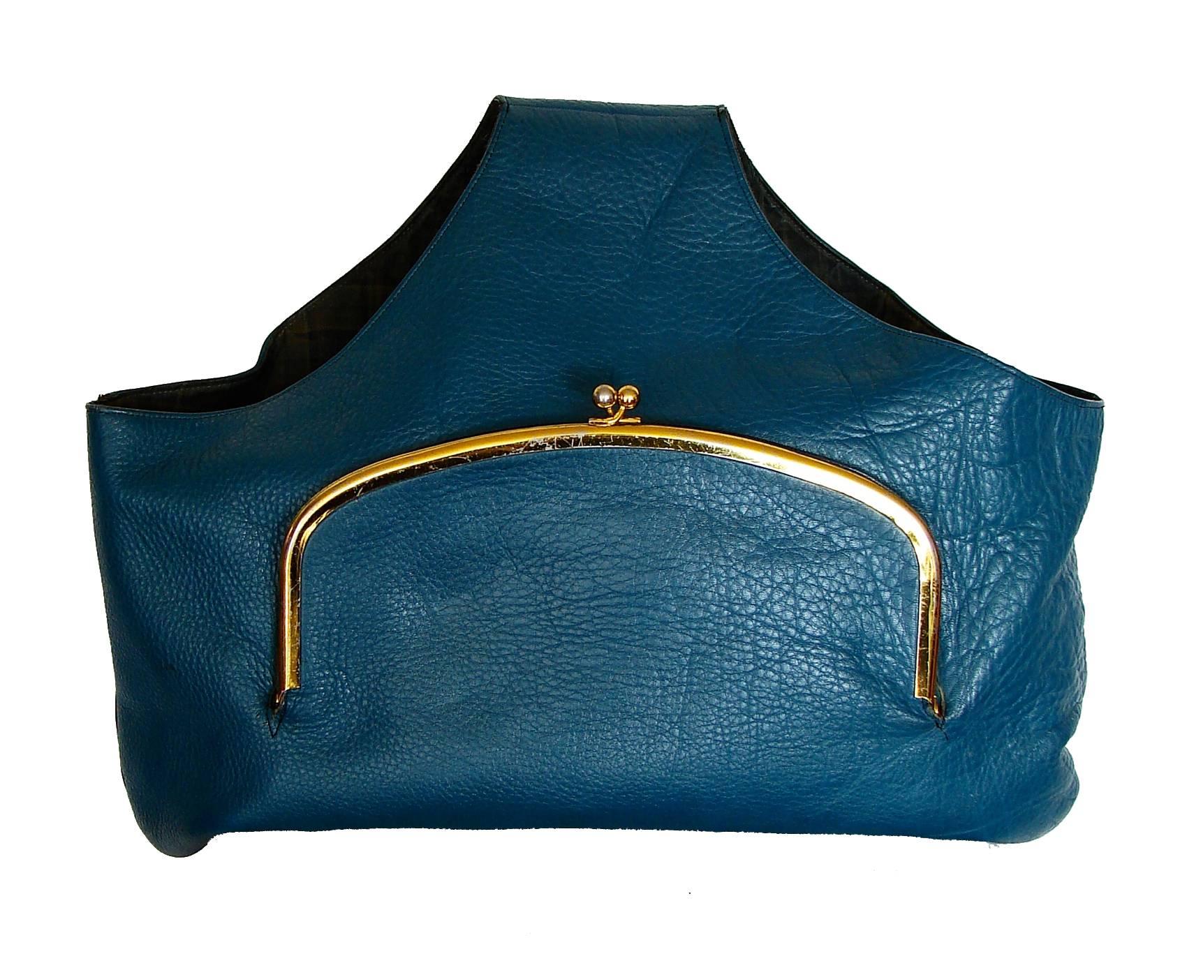 This fabulous tote bag was designed by Bonnie Cashin for Coach in NYC during the 1960s and reflects her practical yet stylish aesthetic.  Made from a vibrant "blueberry" blue leather, this bag features a large brass kiss lock pouch in