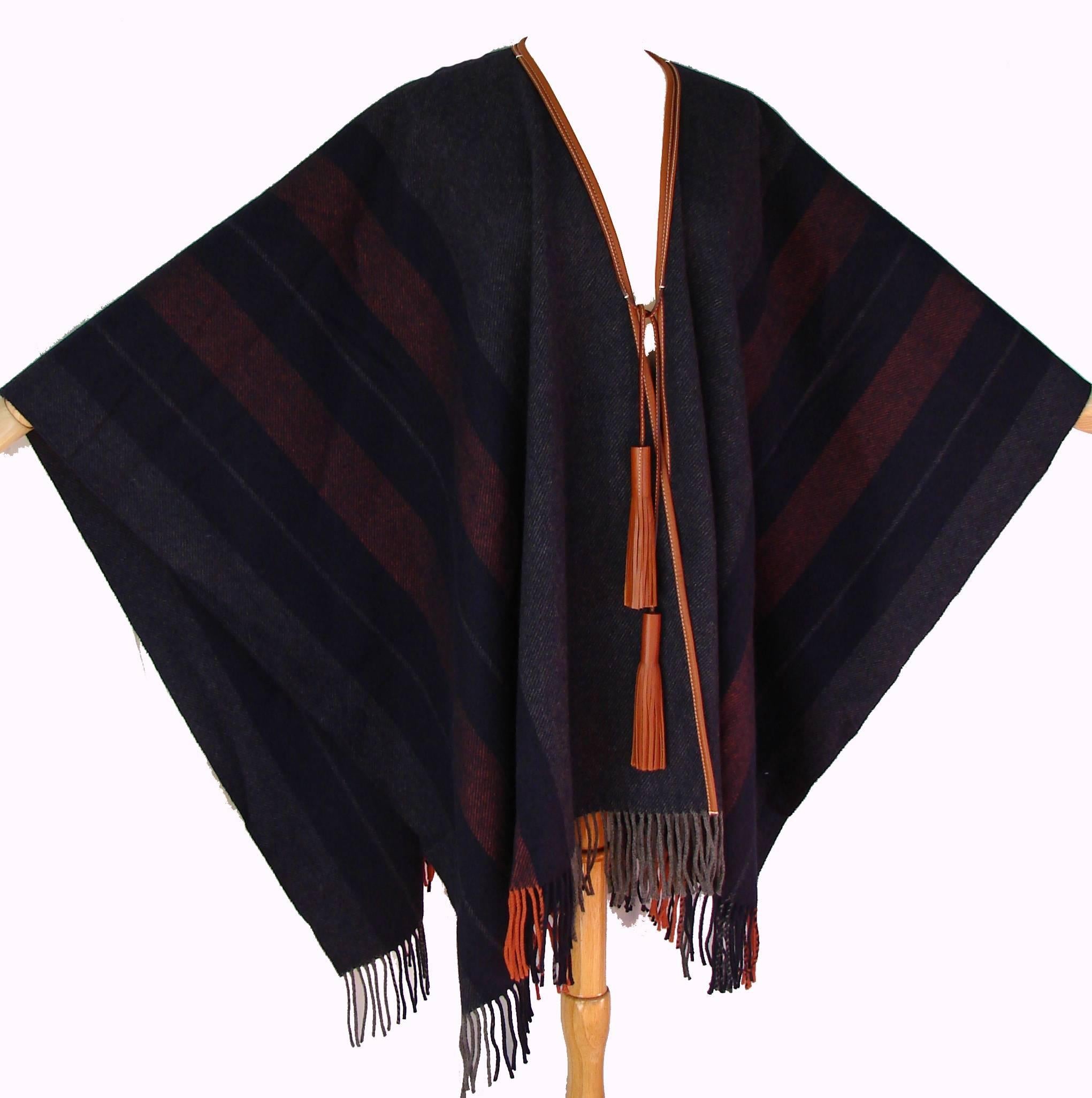 This gorgeous fringed blue Rocabar poncho or shawl is from Hermes and is new in box but without original store tags.  Made from a cashmere & wool blend and trimmed in saddle leather with tassels.  One size fits most.  Measures 62in x 59in.   