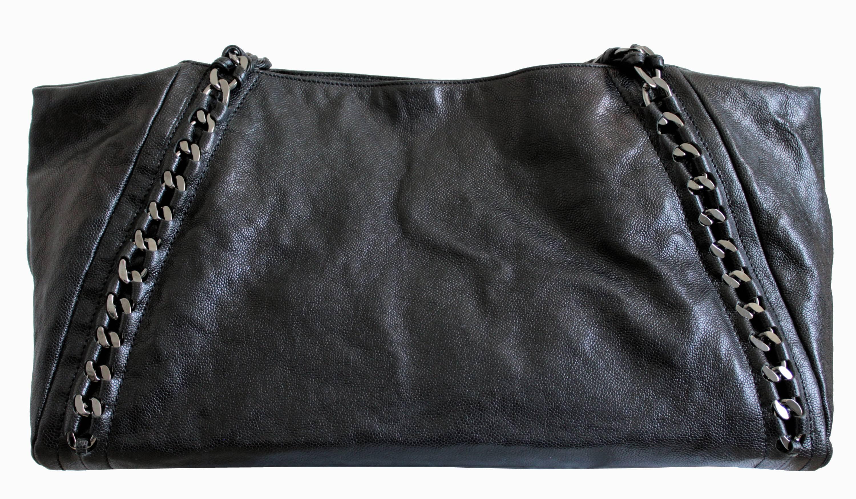 From Chanel circa 2009, this is the extra large Modern Chain tote in black glazed caviar leather. It measures a whopping 17.75inL x 9.5inH x 8inD with a 7.5in strap drop. Fully-lined in silver metallic leather lining, it features a flat zip pocket