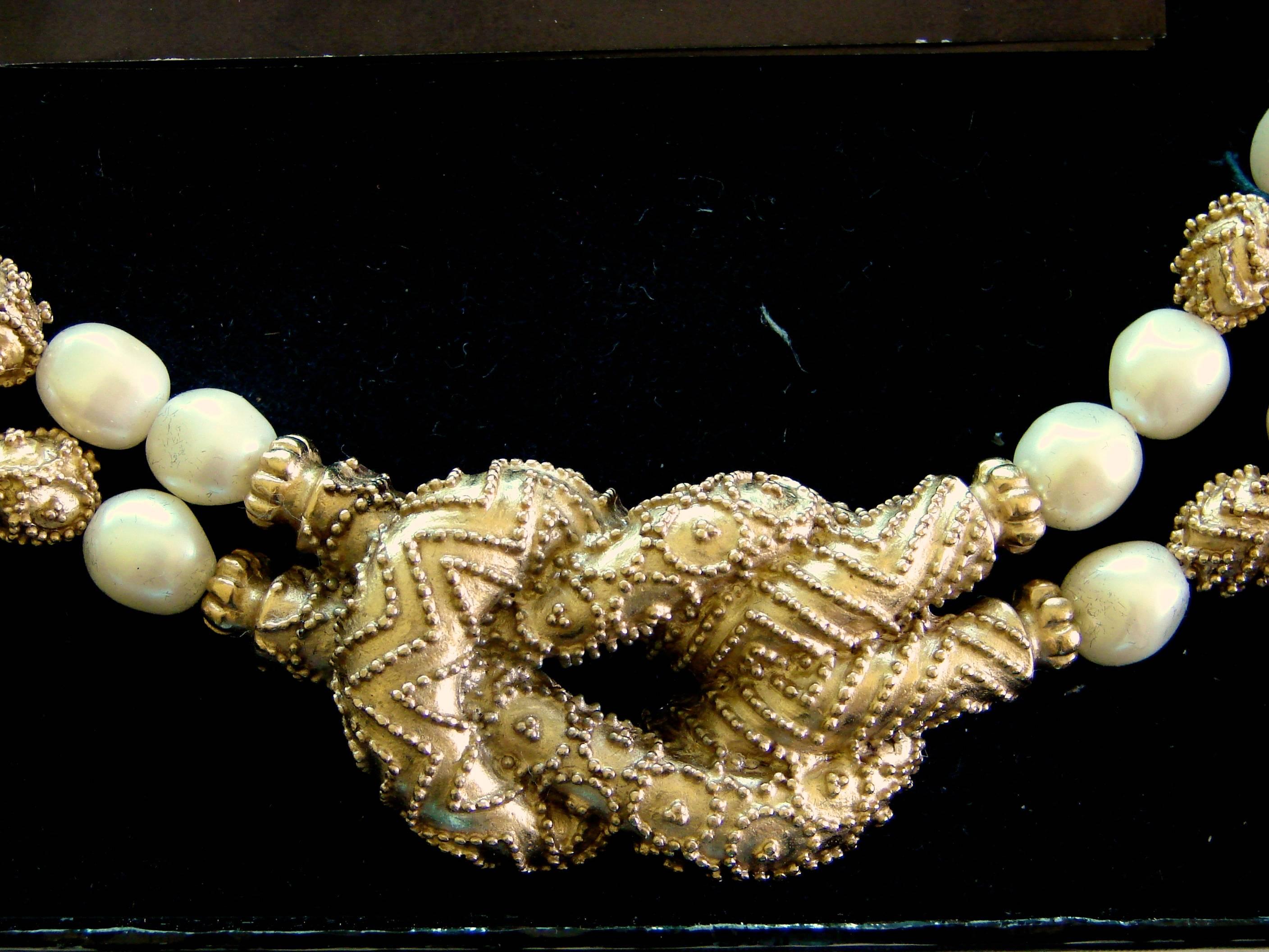 This chic double strand Etruscan style necklace was designed by Mary McFadden in 1988 and sold exclusively by the Franklin Mint as part of a limited edition.  Made from 22ct gold electroplate beads, this piece features faux Baroque pearls and a