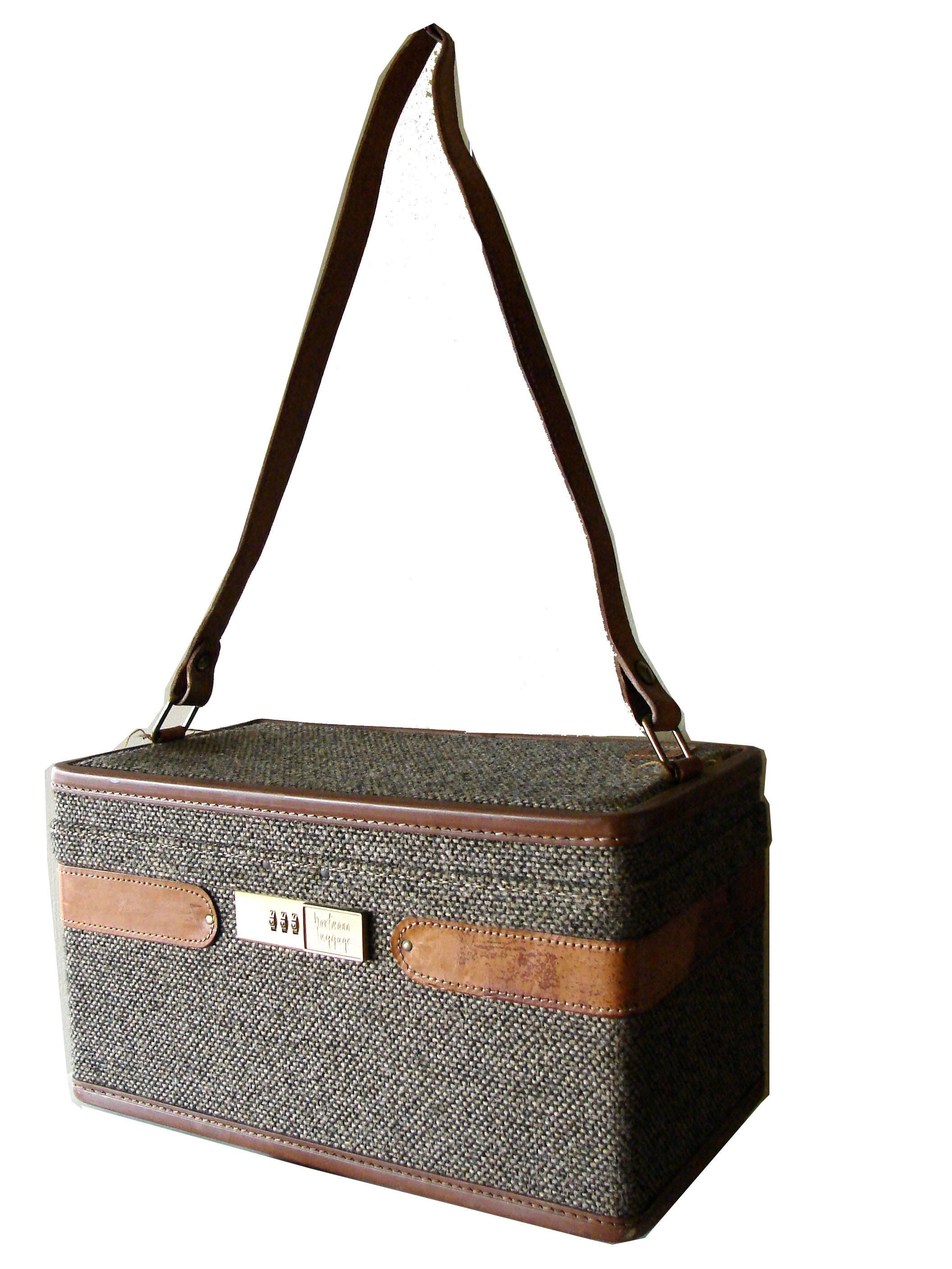This fabulous train case or cosmetics case was made by Hartmann in the late 1970s.  Made from a nubby brown and cream tweed, it's trimmed in tan saddle leather and features a toile fabric interior lining.  In very good condition for its age, we note