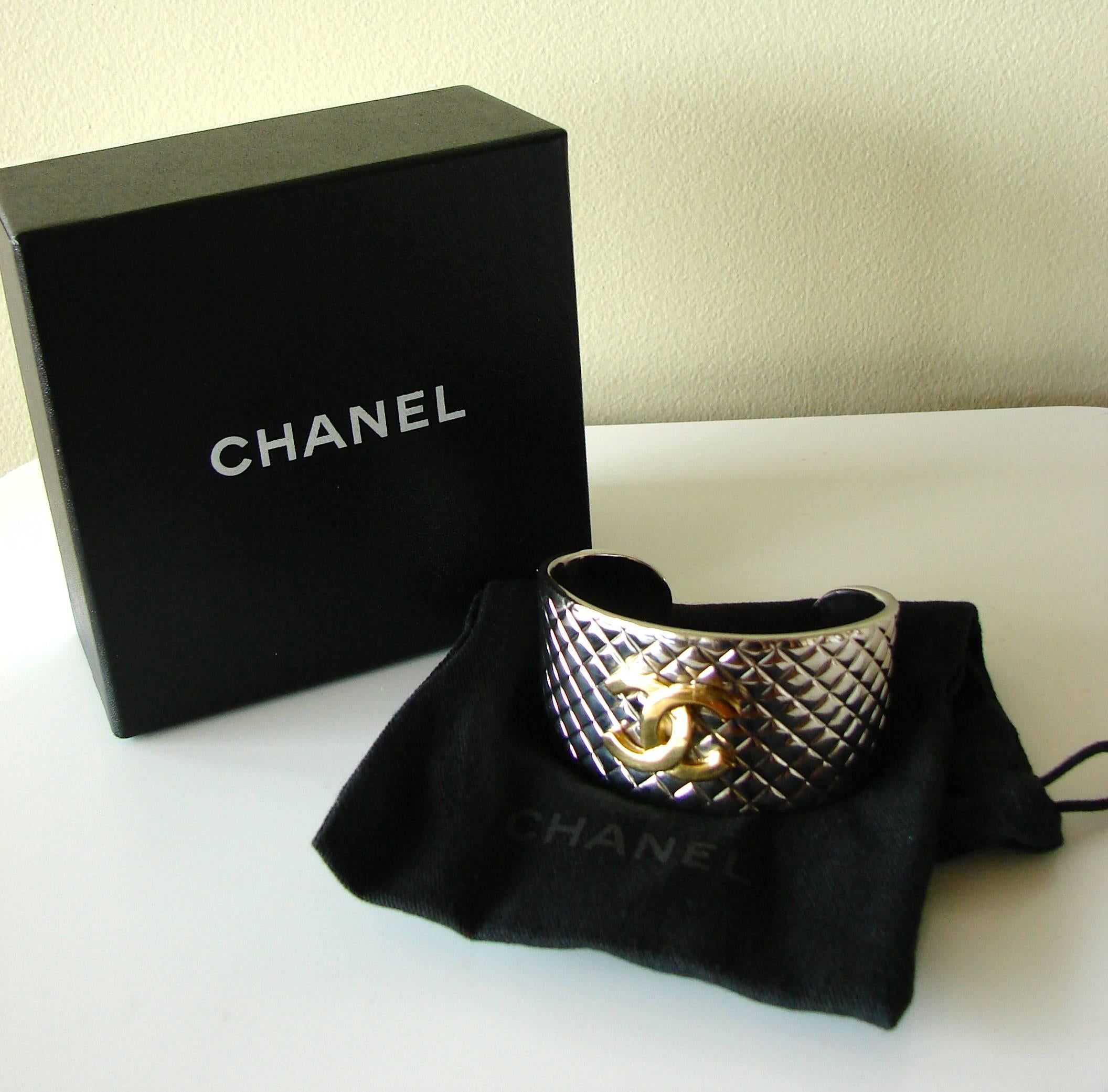 This bracelet was made by Chanel for their 98P collection.  Made from silver metal in Chanel's iconic Matalasse pattern, it features a gold metal CC logo at the center.  In excellent condition, with minor scratching from prior wear, hard to see