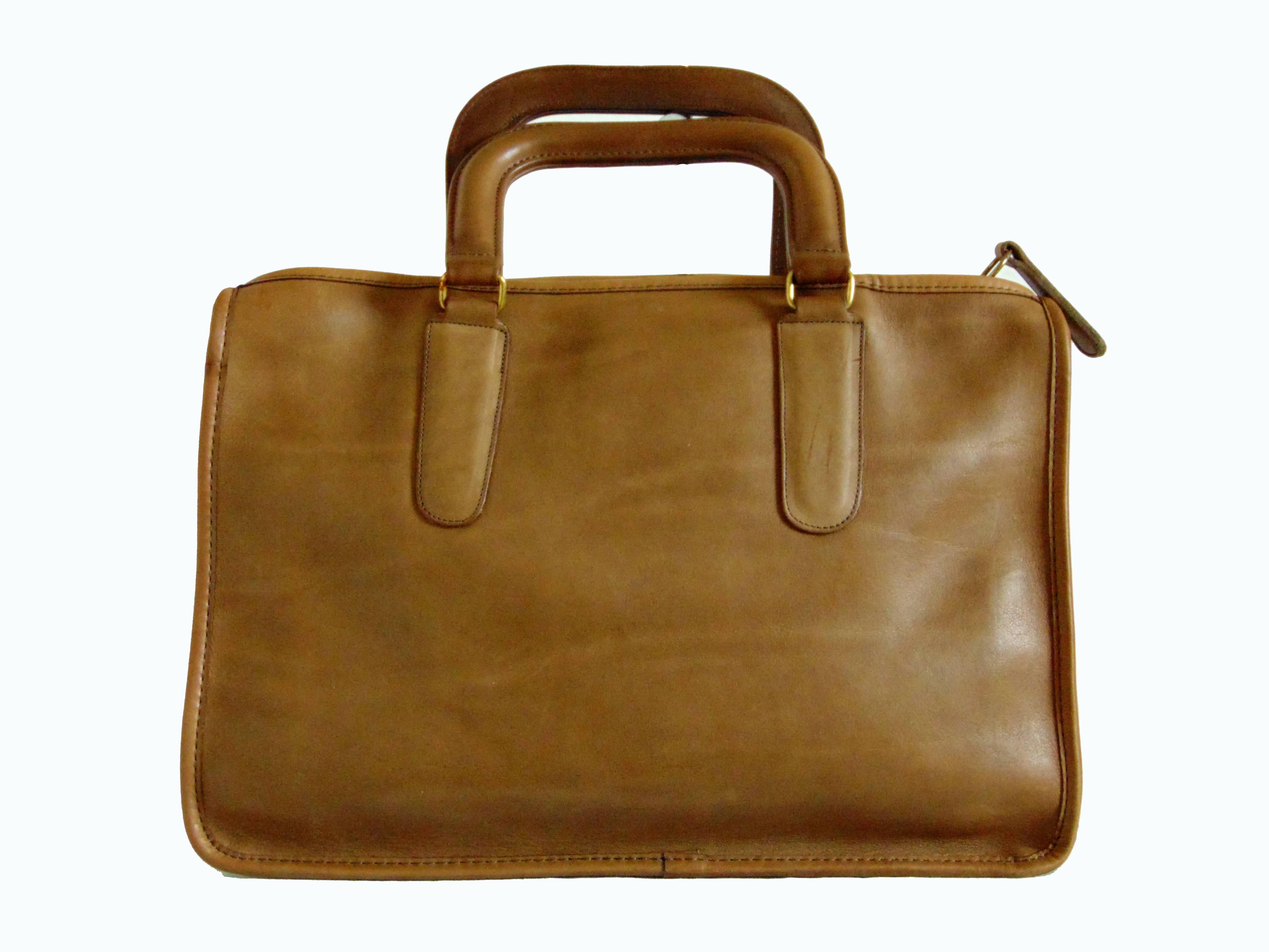 Here's a classic tote bag designed by Bonnie Cashin for Coach Leatherware.  Made from saddle tan leather, the interior is unlined and features one large zip pocket.  Fastens with a chunky brass zipper.  In excellent condition for its age, this piece