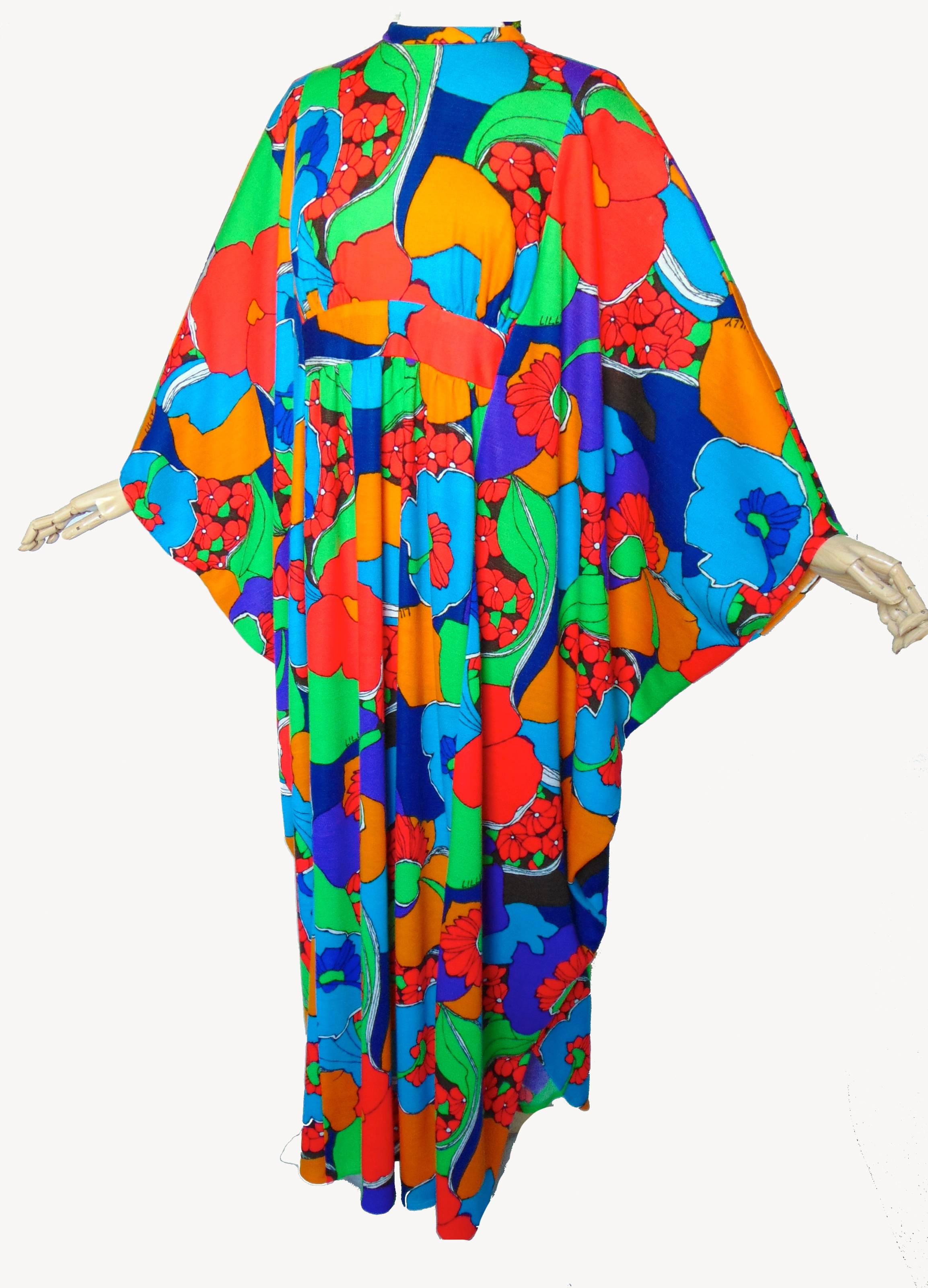 This fabulous Kaftan or Caftan dress was made by Lilly Pulitzer in the early 1970s.  Made from polyester, the fabric features swirling graphic florals in shades of red, orange, aqua, blue, purple, green and white as well as the 