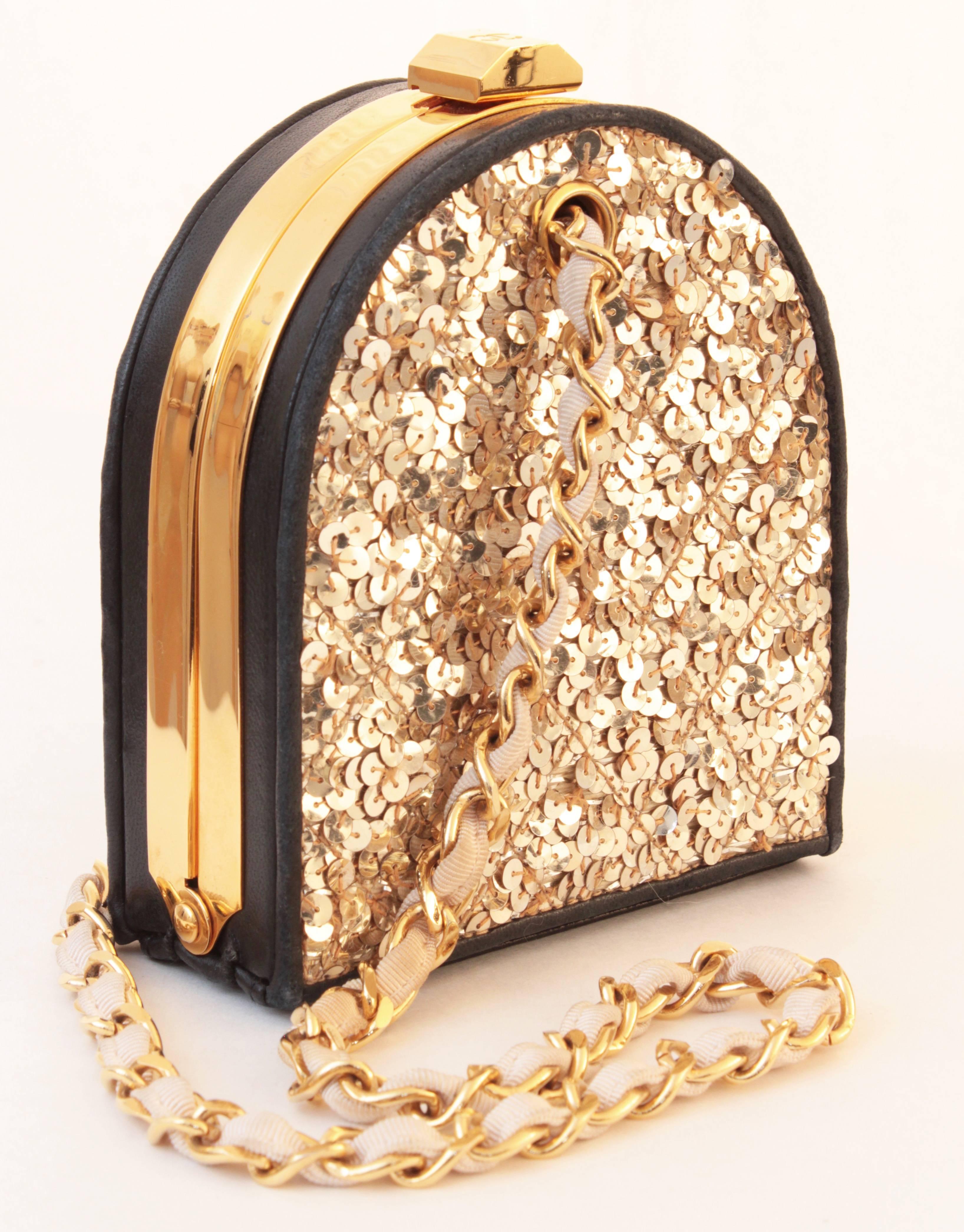 This chic evening bag was made by Chanel and features a structured black leather and gold metal exterior with glimmering sequins.  The interior is lined in black lambskin and features a small elasticized pocket.  The silk and gold chain straps can