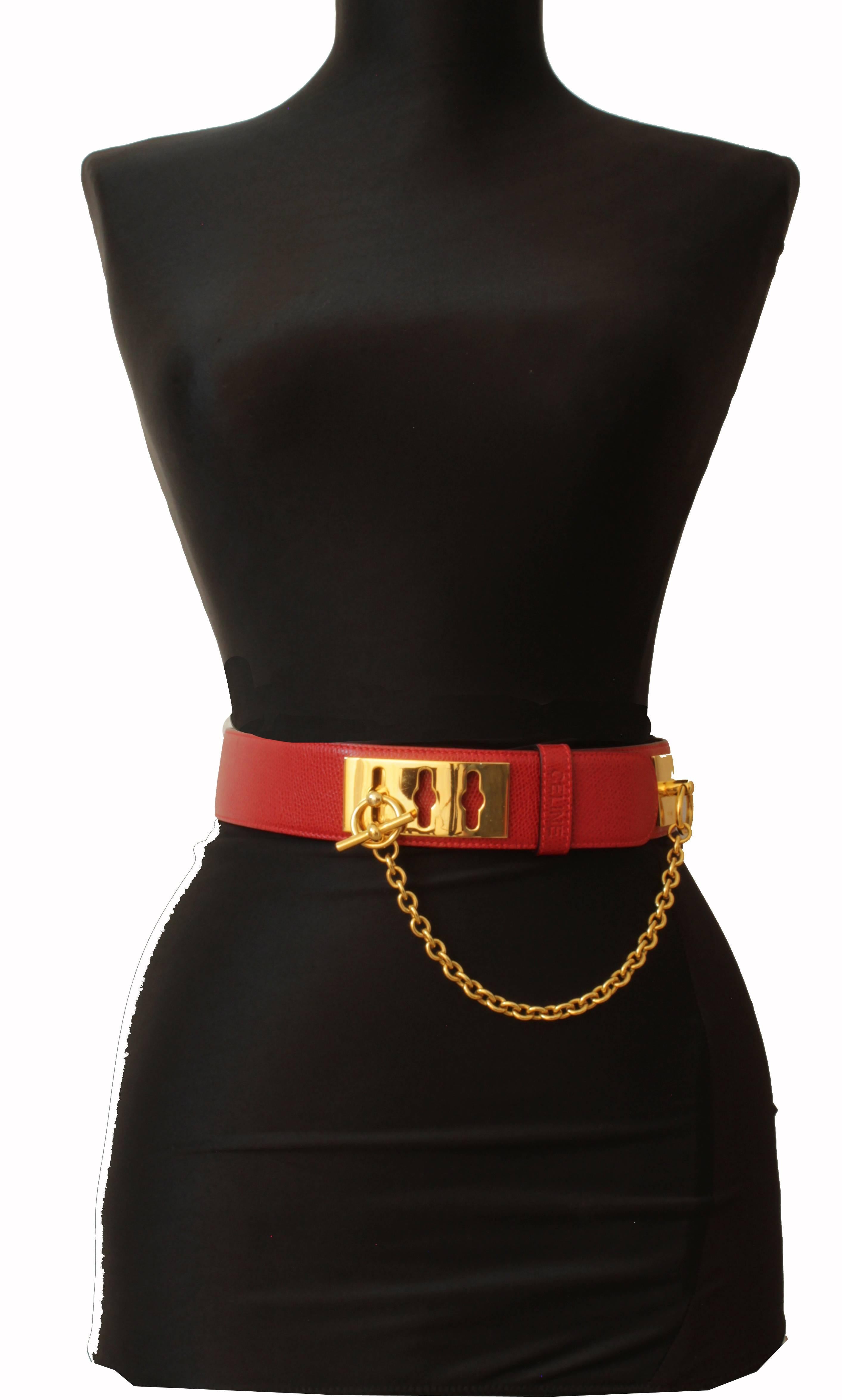 Here's a chic leather belt from Celine Paris.  Made from red leather, it features a gold plate and loop fastener with gold chain.  Tagged size 65cm, this best fits a waist between 24 - 26in.  It measures 32in total length and is 1.5in wide.  Stamped