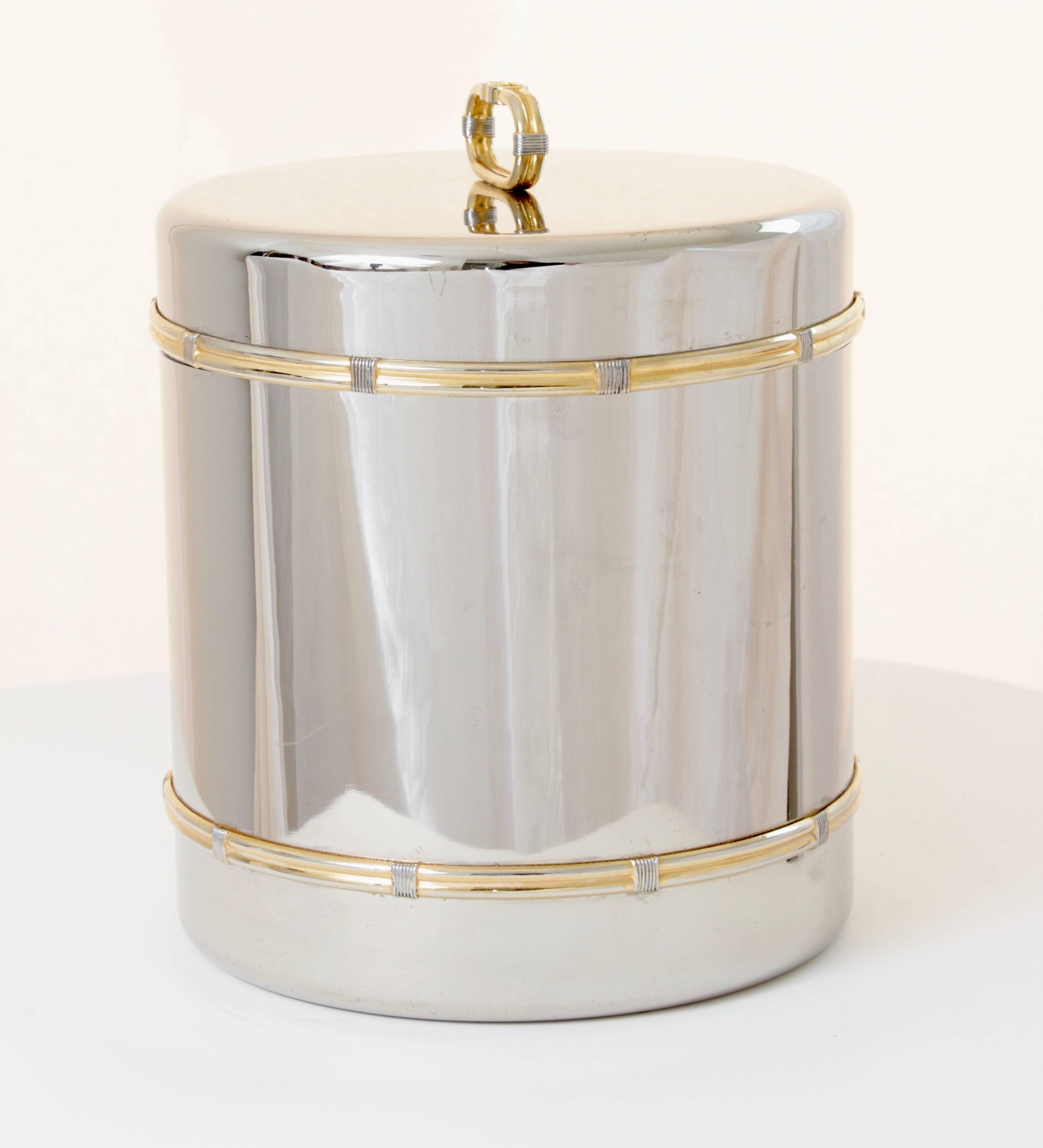 This rare ice bucket or champagne cooler was made by Gucci, most likely in the late 1970s.  Made from a silver metal, it features gold metal rope accents on the cooler and GG logo on the lid handle.  Comes with Gucci GG logo ice tongs.  Both barware