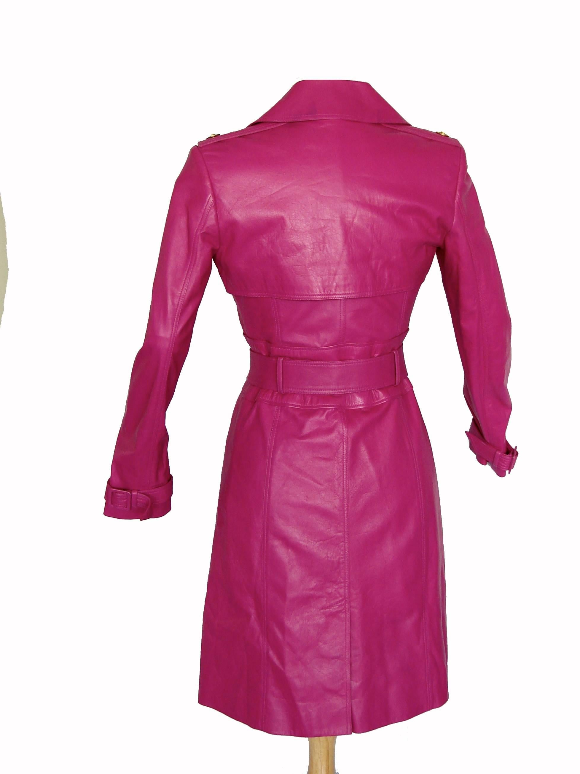 This brilliant magenta leather coat was made by Versace in 2011.  Made from an incredibly soft lambskin leather, it features four gold metal Medusa buttons to fasten in front, a tie-wrap belt, epaulets and a storm flap on the back.  Fully lined in