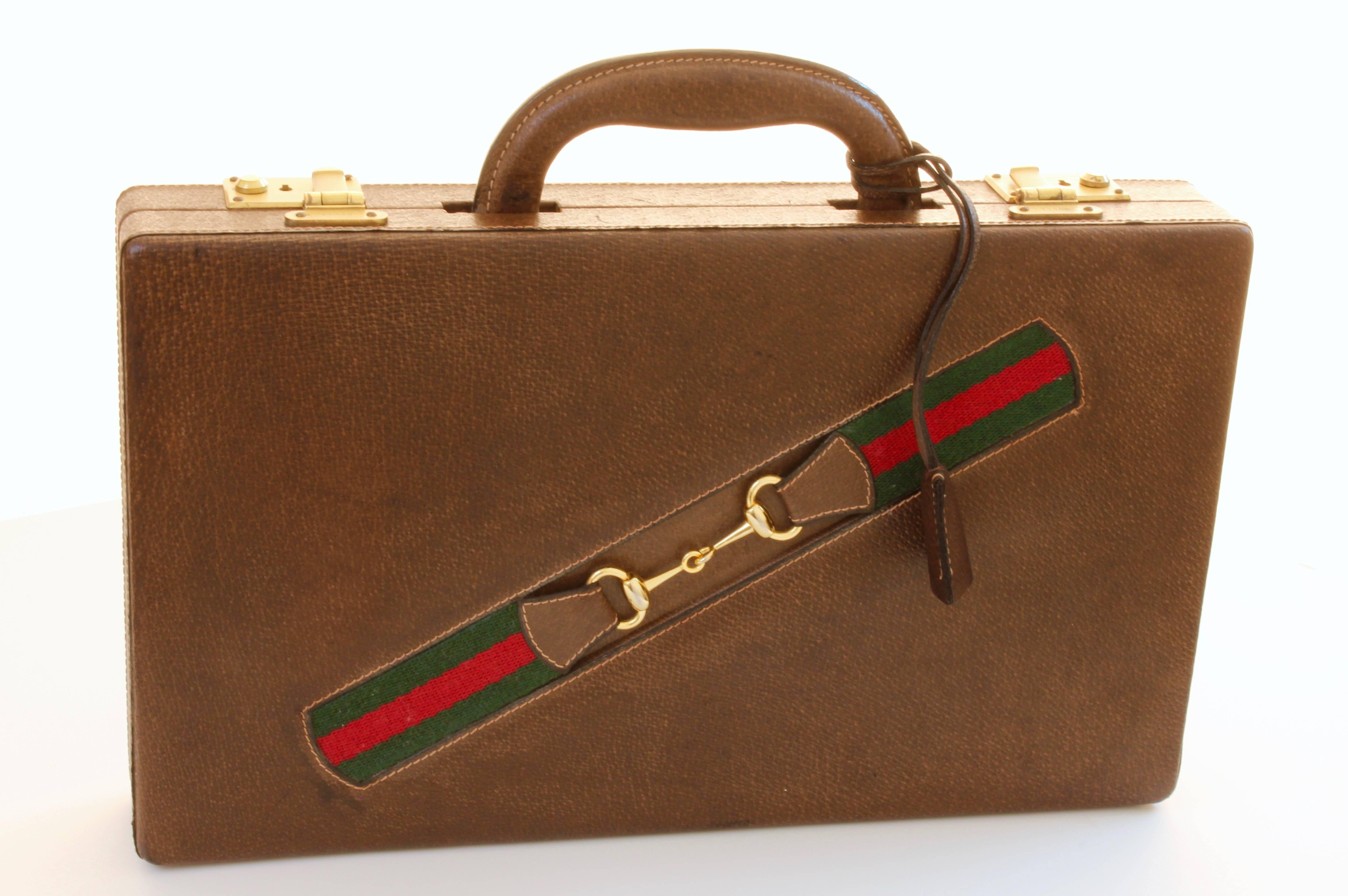 This vintage portable backgammon set was made by Gucci, most likely in the mid 1970s,  The travel case is made from pigskin leather and features Gucci's iconic webbing with a gold tone horse bit.  Inside, there's a tricolor wood board and removable