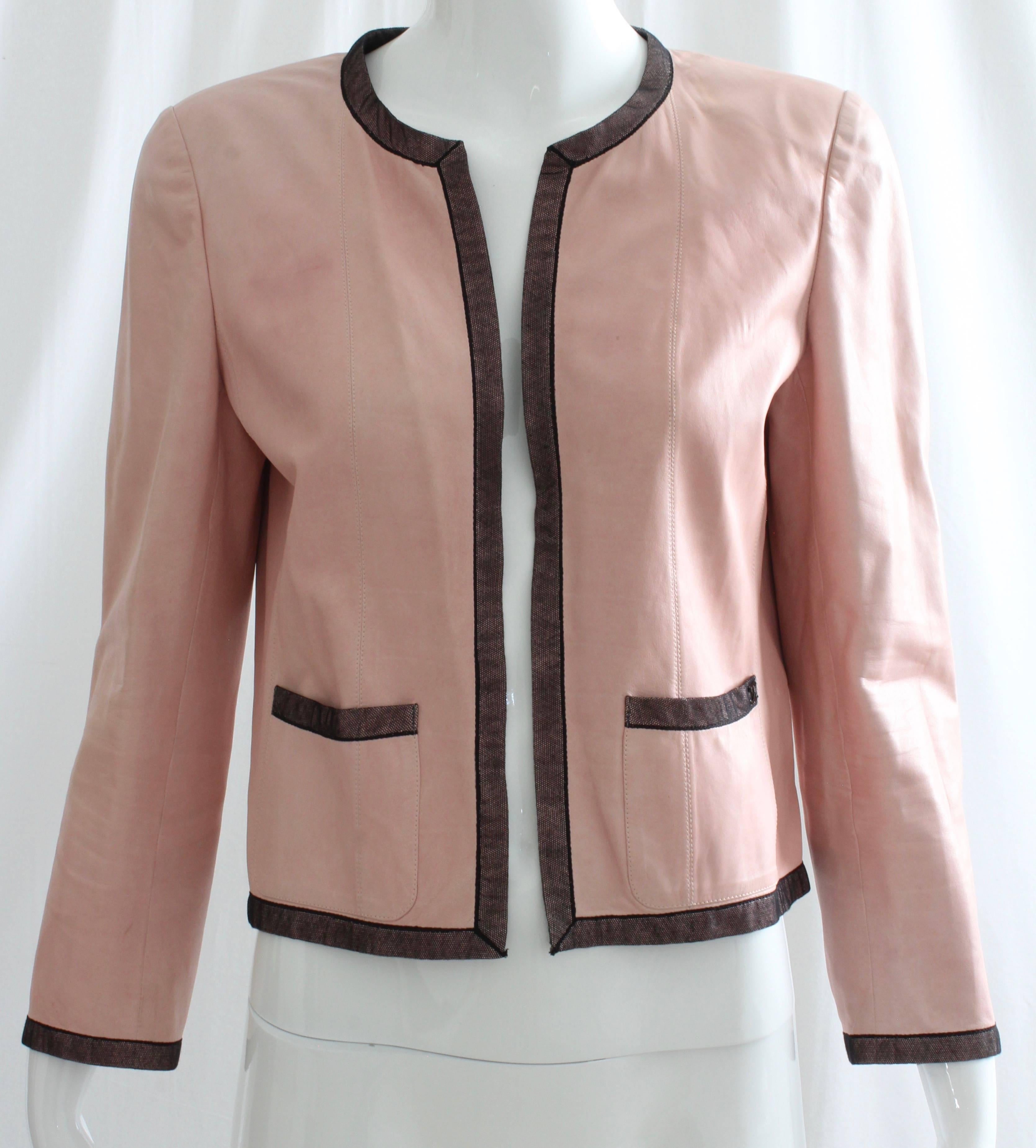 Preowned and authentic Chanel pink leather jacket with black mesh trim. Unlined and no closures (meant to wear open). Preowned/vintage w/signs of use/wear: pencil tip spot to right sleeve bottom, marker tip size spot to left side of chest & one