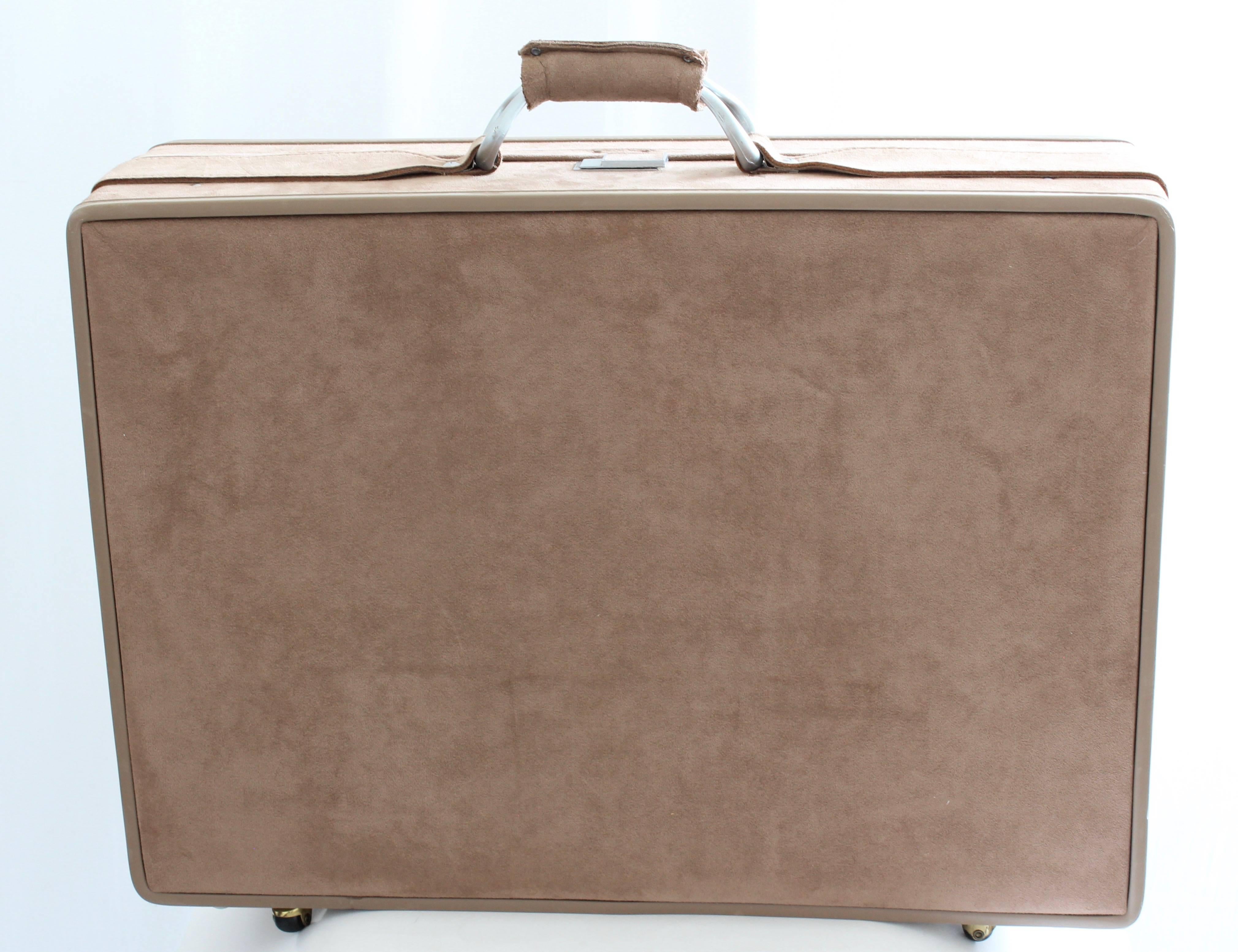 Here's a 25in belting suitcase from Hartmann, most likely made in the early 80s.  Made from taupe sueded fabric, this was part of a larger collection we recently acquired that was designed by Halston for Hartmann (see image 16, where we show all