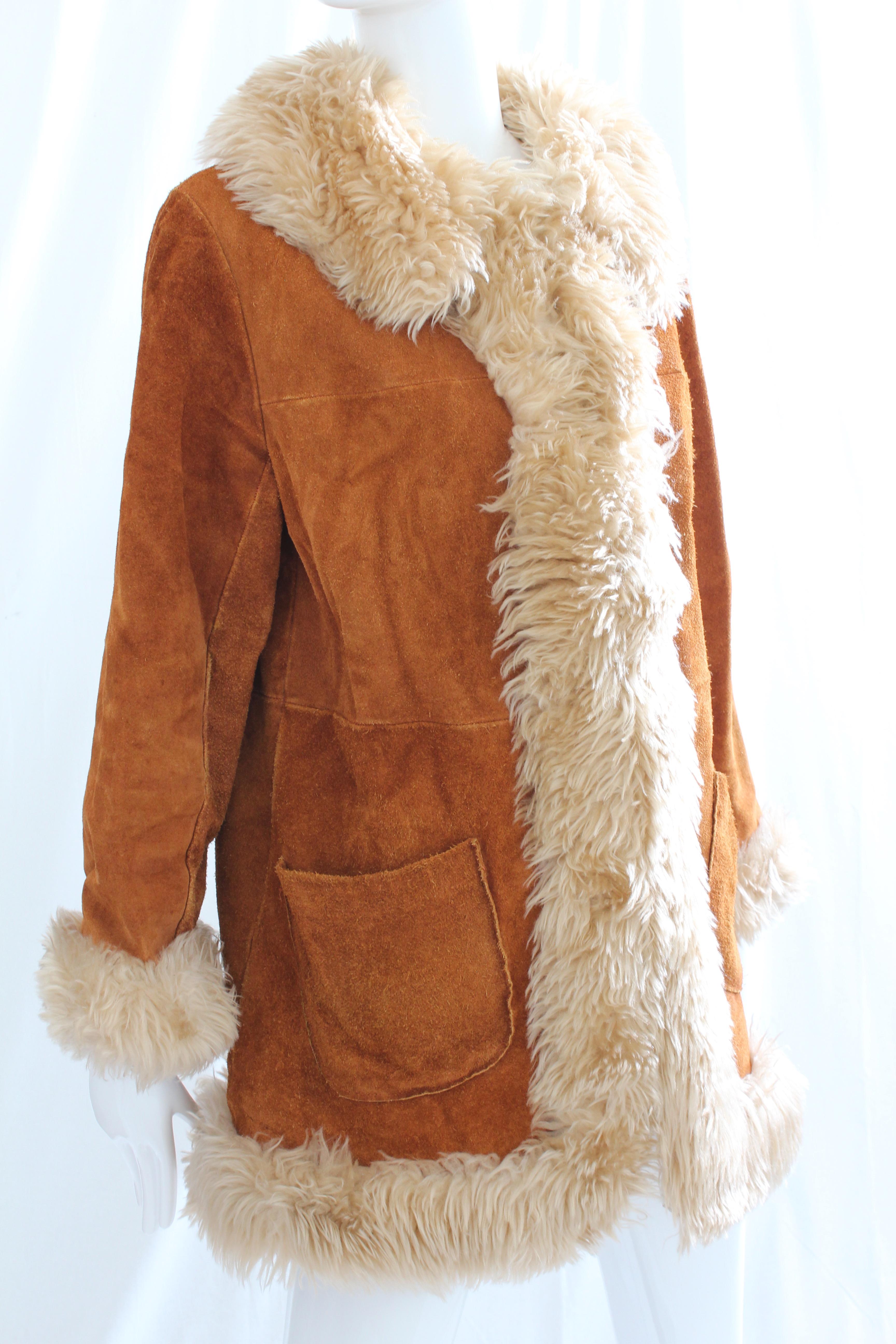 This fabulous vintage coat was made by Leathercraft NYC, most likely in the mid 1970s.  Made from suede leather, it's lined in faux shearling and trimmed in shaggy faux fur.  Fastens with hook/eye fasteners and features two side pockets.  In good