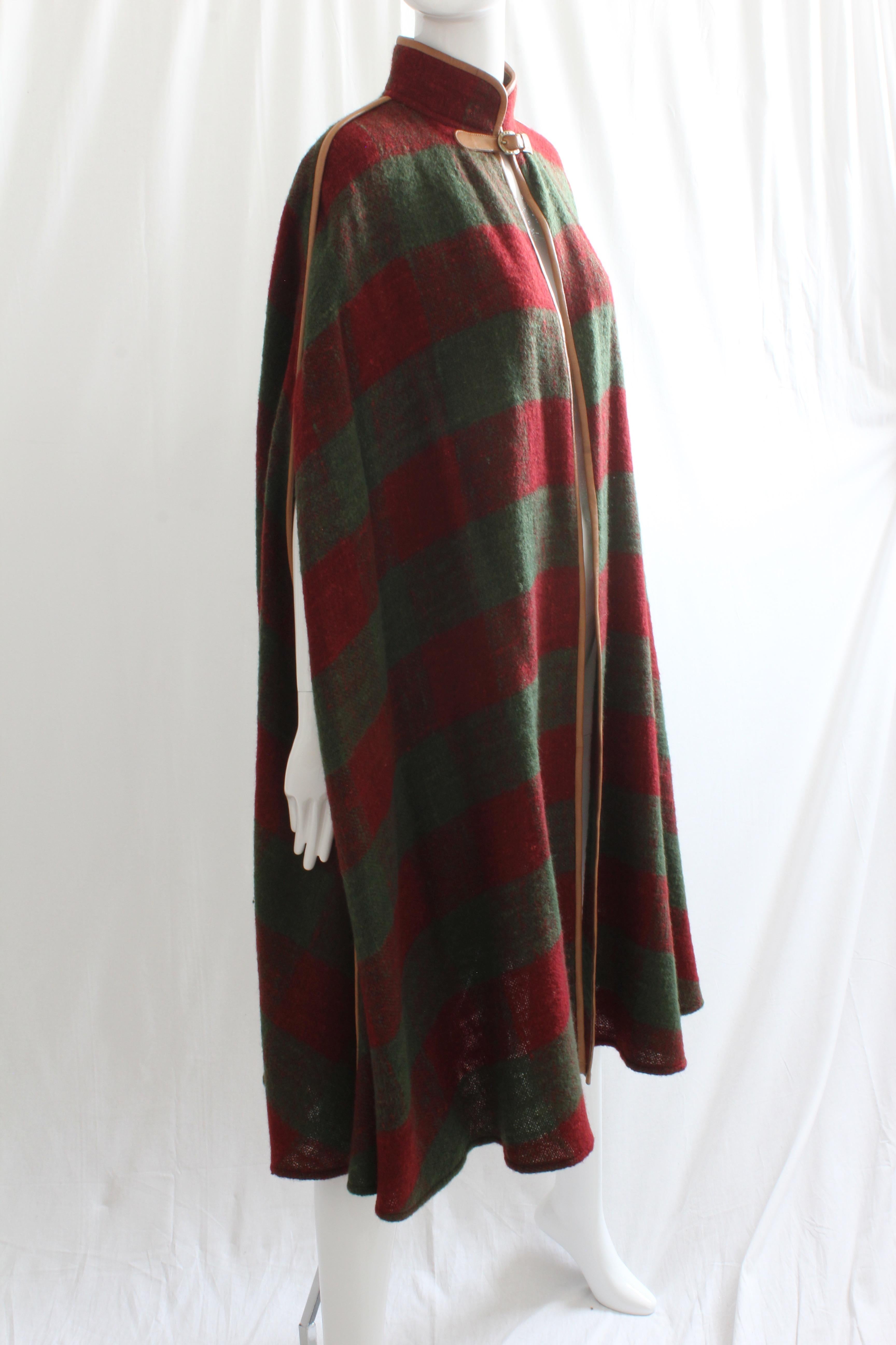 This long cape was made by Gucci, most likely in the late 70s or early 80s.  Made from supple lightweight wool in their signature web colors of green and red, it features saddle leather trim and a gold tone horse shoe buckle at the collar.  So hard