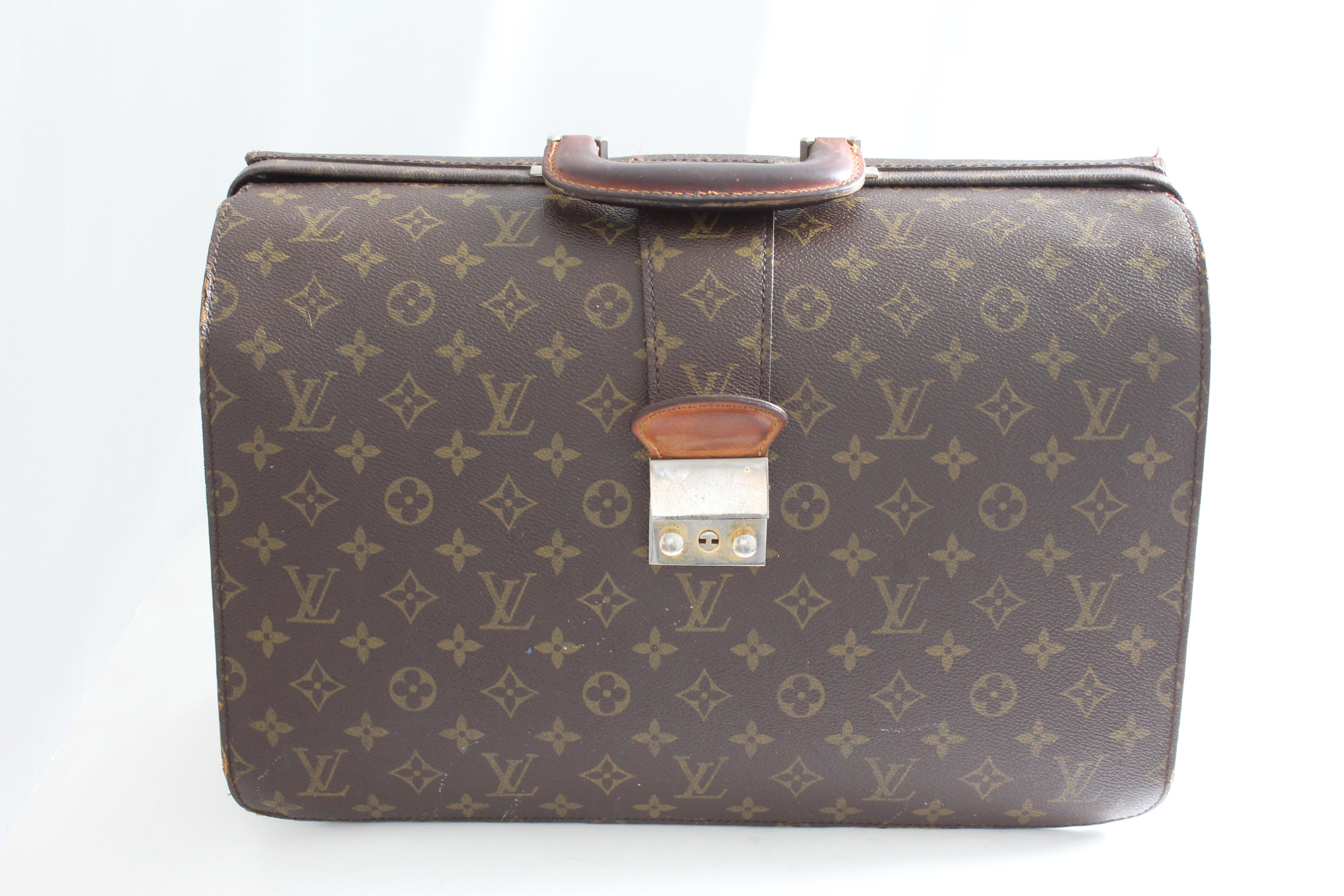 Work and travel in style with this vintage Serviette Fermoir briefcase or business bag, made by Louis Vuitton and sold by Saks 5th Avenue, most likely in the 1980s. Made from LV's signature monogram canvas, it features a leather handle and three