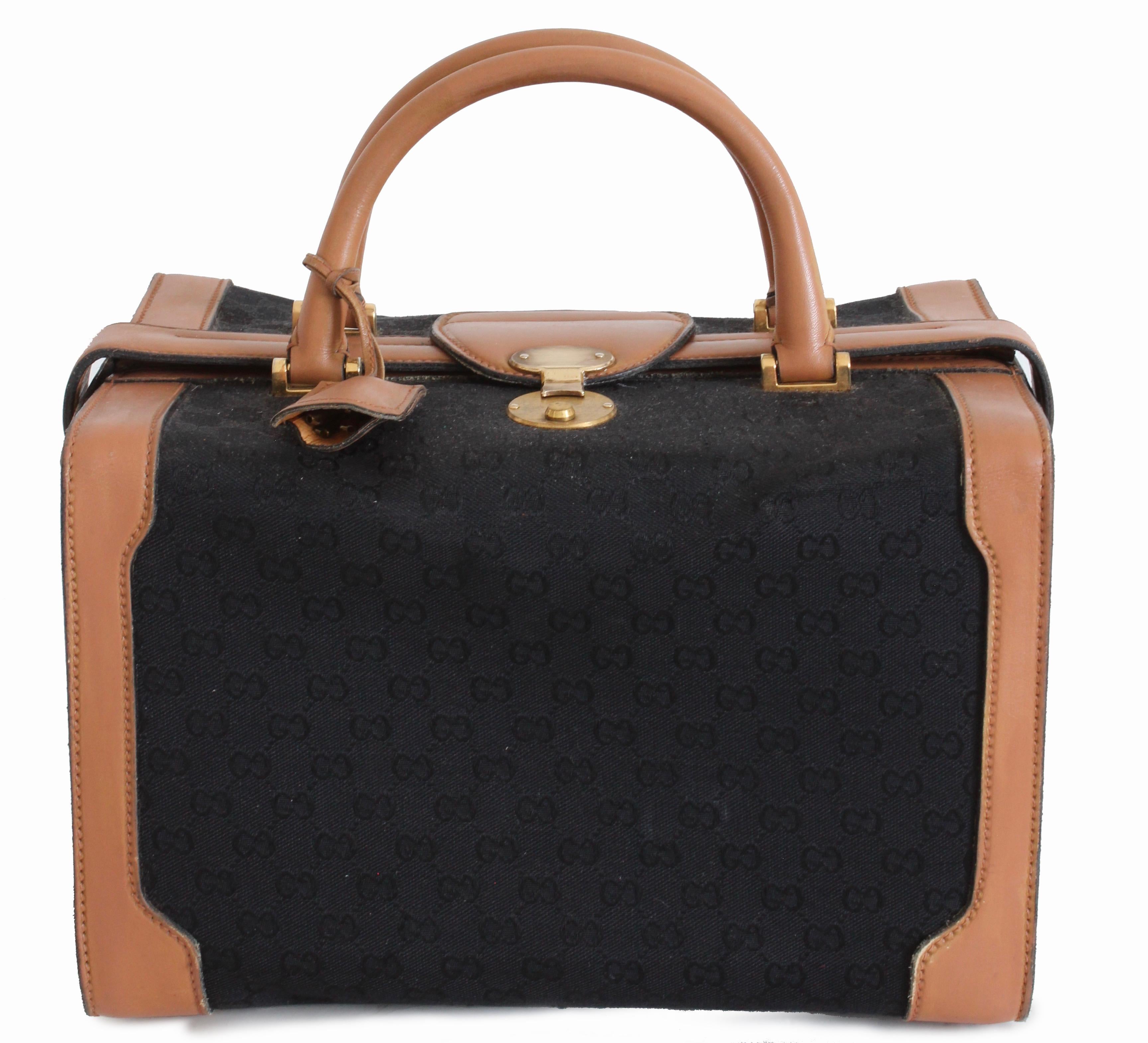 This super rare train case or vanity bag was made by GUCCI, most likely in the late 1970s.  Made from their monogram canvas in black, it features tan leather trim and a doctors bag construction.  The interior is lined in leatherette fabric and