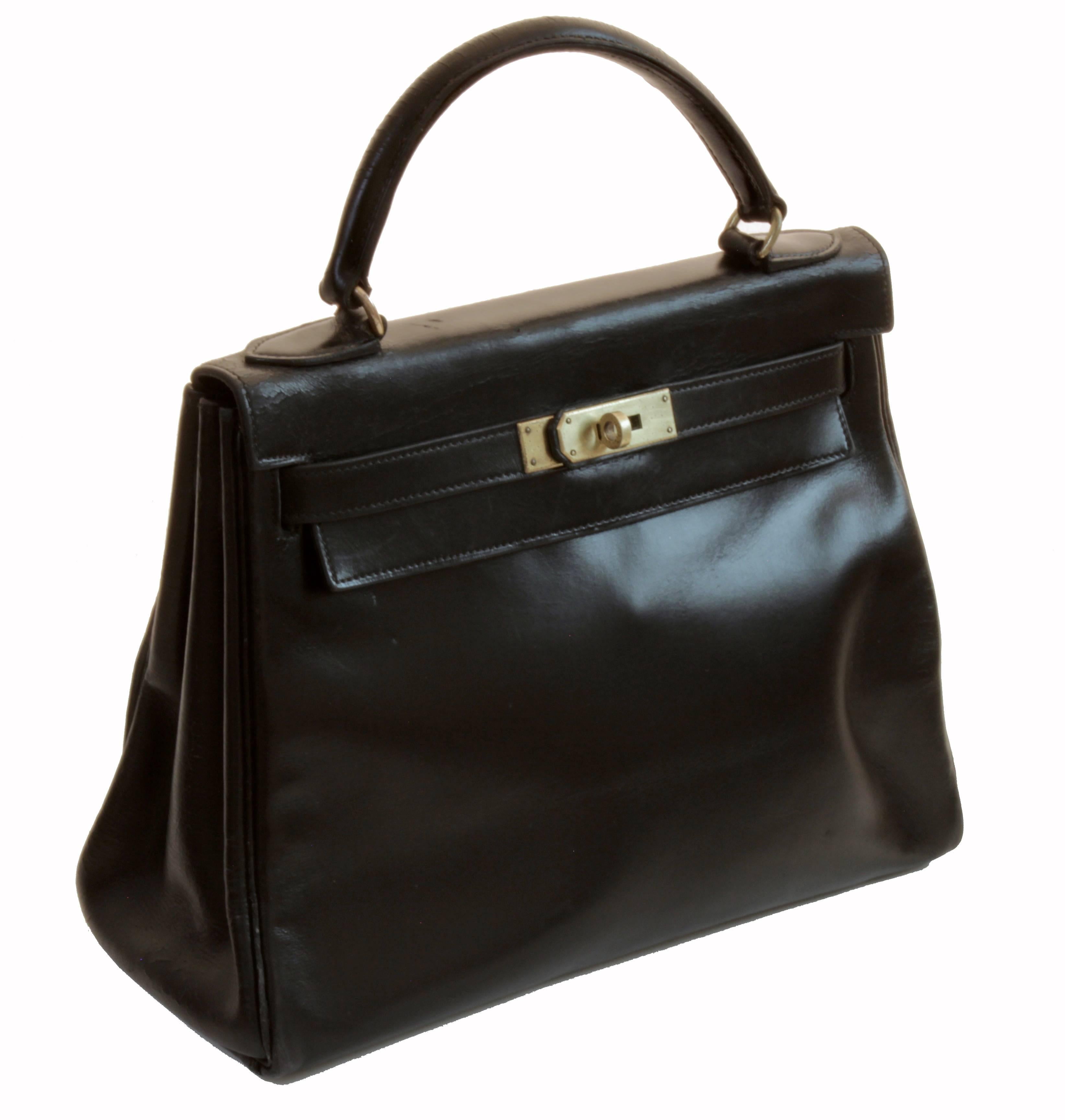 This iconic top handle bag was made by Hermes in 1948, years before Grace Kelly made the bag famous, prompting Hermes to eventually rename it The Kelly Bag.  Made from black box leather with gold tone hardware, this is the 28cm version and measures