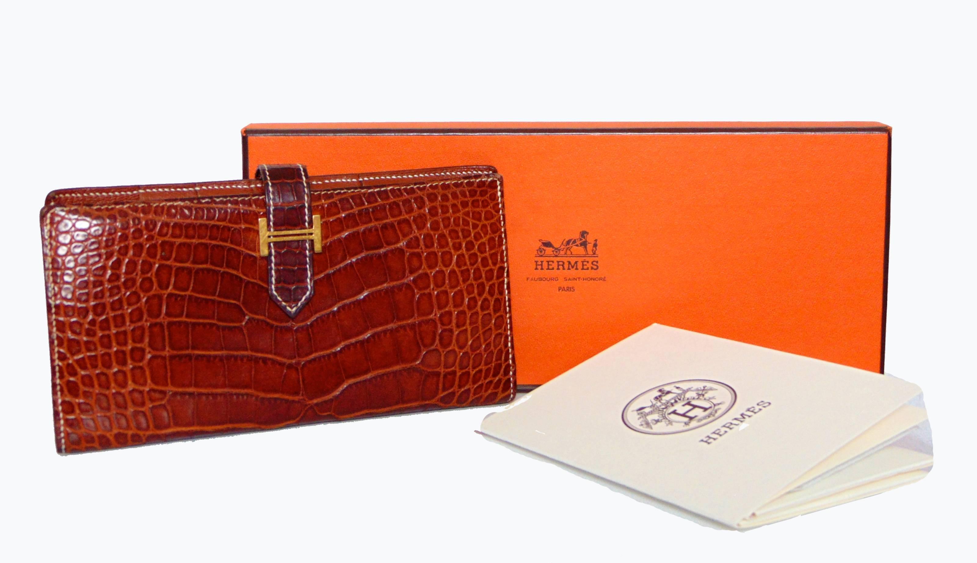 This incredible wallet was made by Hermes in 2004.  Made from their signature alligator skins in a rich honey or Miel color, this wallet features white contrast stitching and fastens with a gusset.  The interior is lined in matching honey goatskin. 