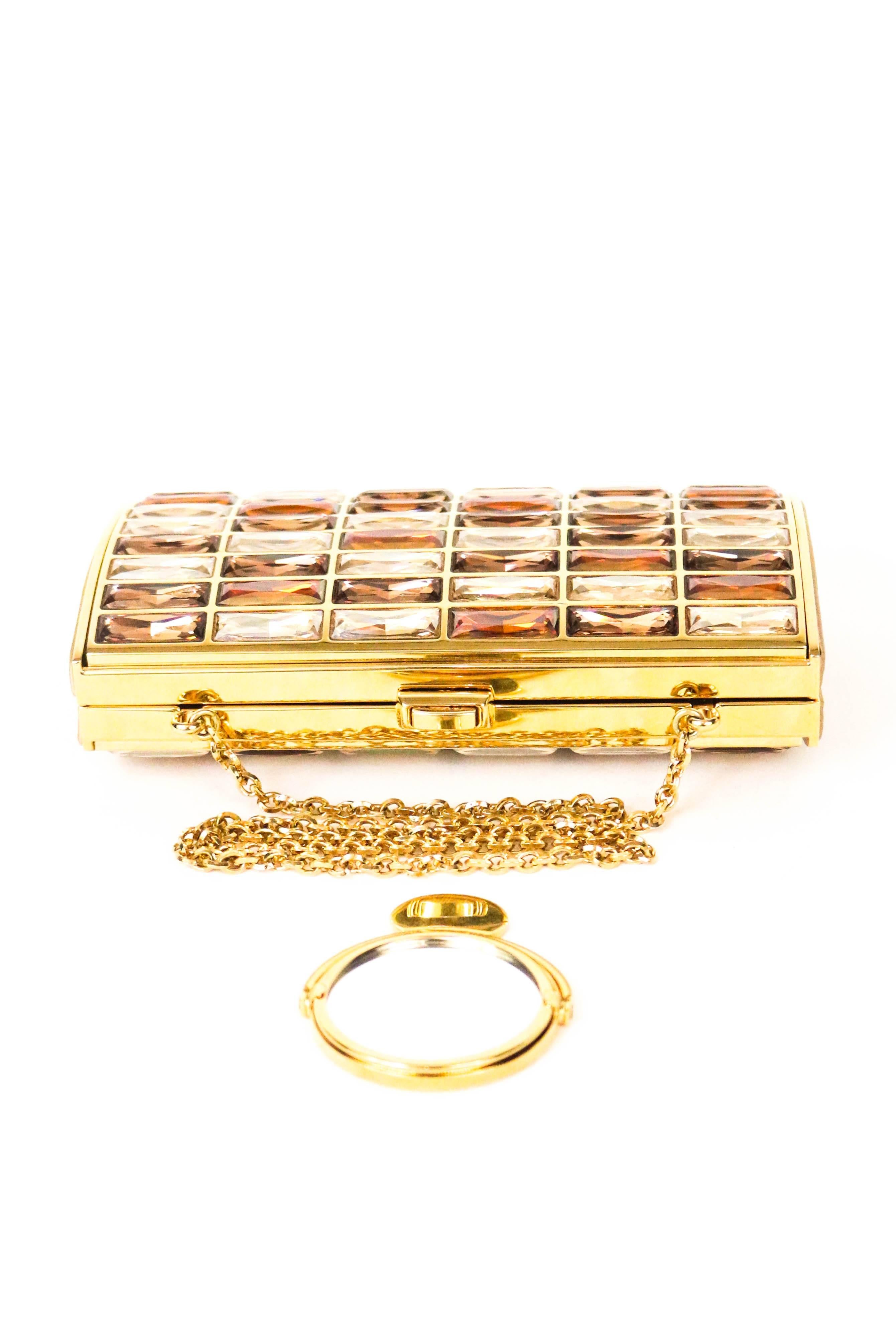 Offered is an authentic and stunning piece by Judith Leiber, the Goddess clutch in bronze and gold. A beautiful gold tone frame trimmed with shimmering crystals in gold, bronze, and clear.  Supple gold leather lining.  Comes with signature small