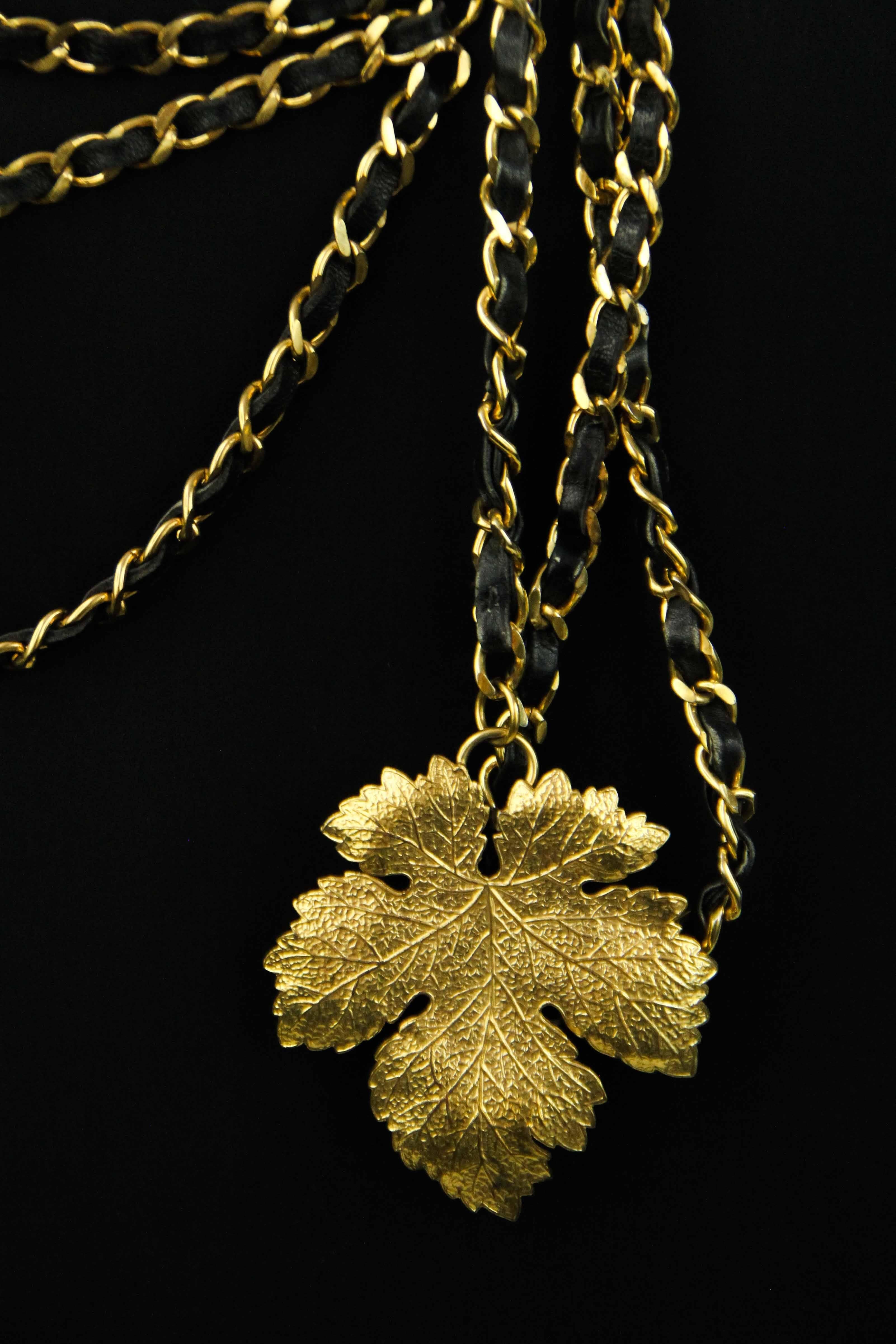 Offered is a very rare and unique piece from Chanel, the one of a kind fig leaf belt in brilliant gold tone with the signature leather intwined chain belt.  In the center is one large metal fig leaf designed to be worn low on the waste , an alluring