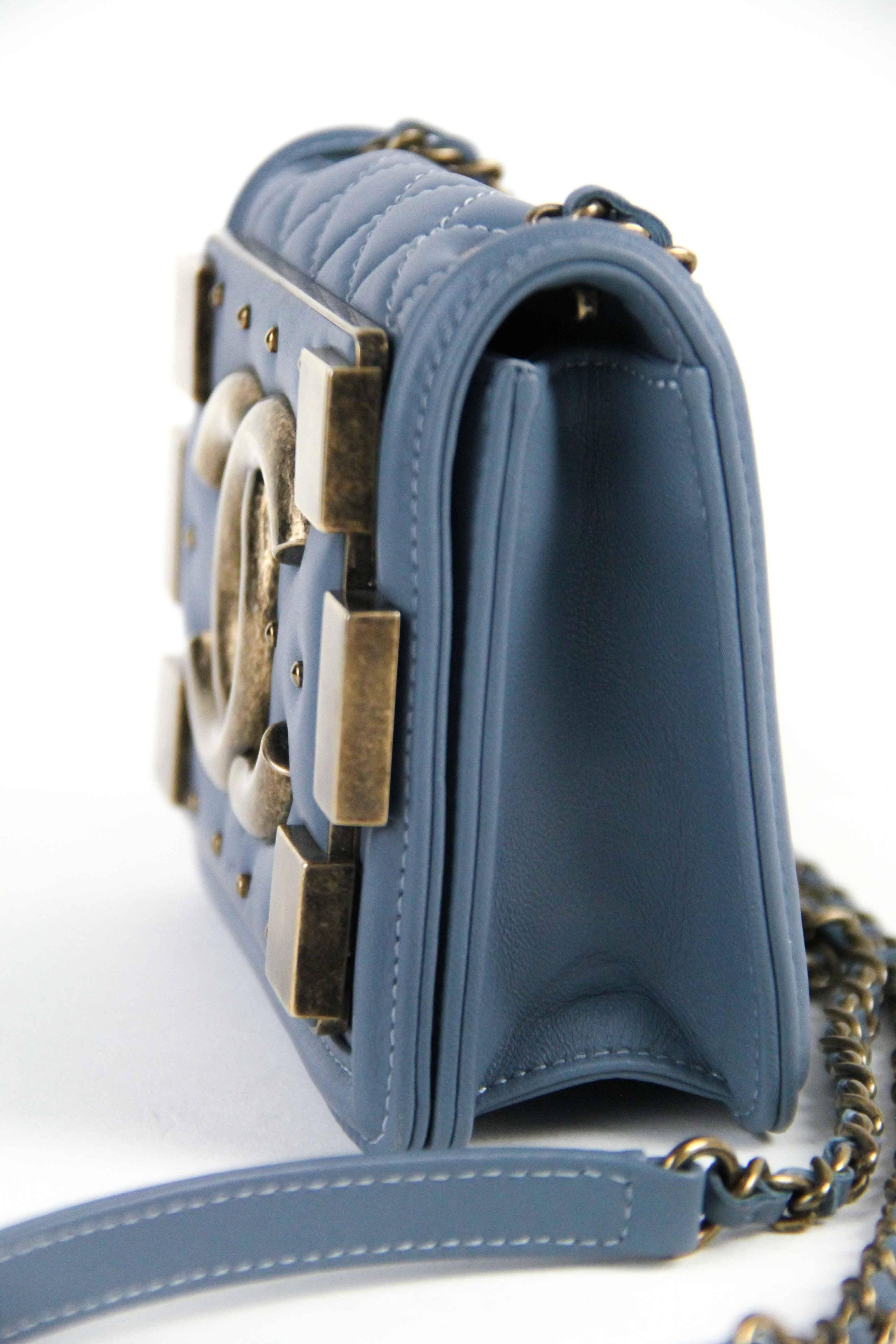 Offered is this darling Chanel Boy Bag with a brick flap with Gold-tone hardware. Blue jean color lambskin accented with aged gold-tone CC logo, Chain shoulder stap with flat leather at shoulder.  This style is one of the most in demand sillouettes