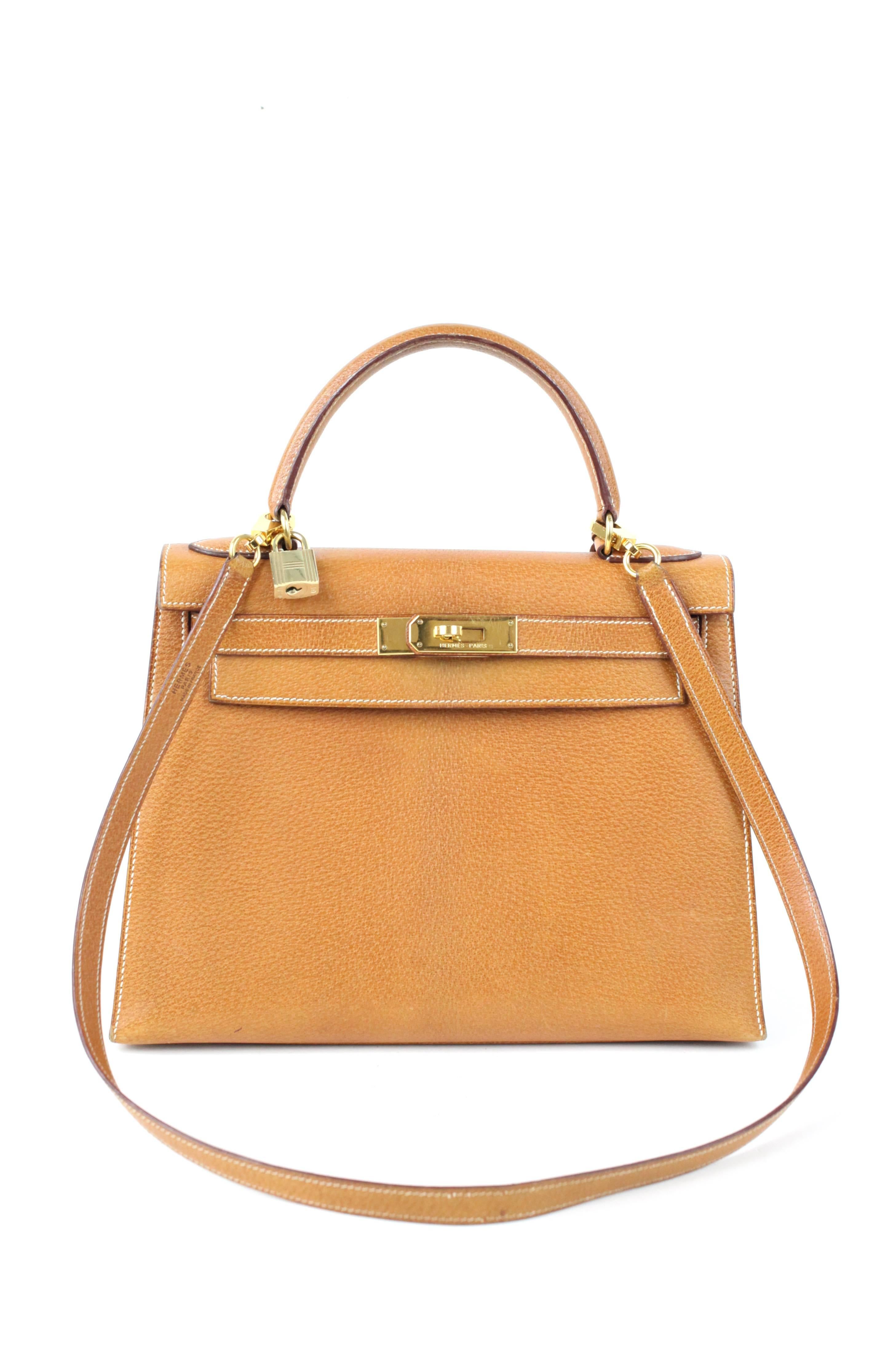 Offered is an incredibly well kept Hermes Kelly Retourne 28 cm in Pigskin leather. This style can be worn as a shoulder bag or a top handle. As this is a vintage bag there are several signs of wear across the bag.  There are scratches on the