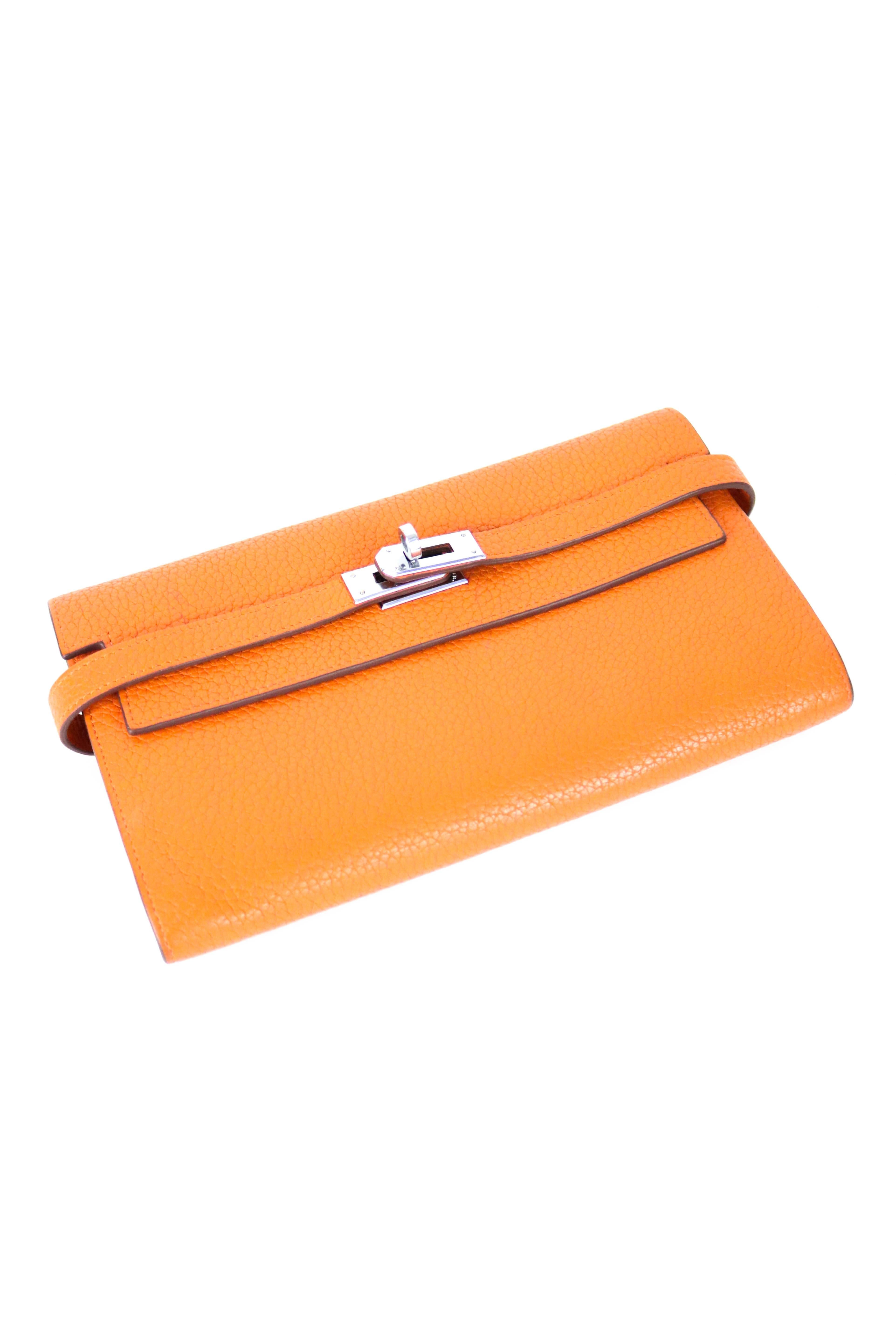 Offered is an Authentic Hermes Kelly Long Clutch Wallet in Orange Chèvre Leather.  This is an immediately recognizable Hermes color, known as equestrian  orange.  Palladium hardware coordinates beautifully with the rich hue.  Signature  turn-lock