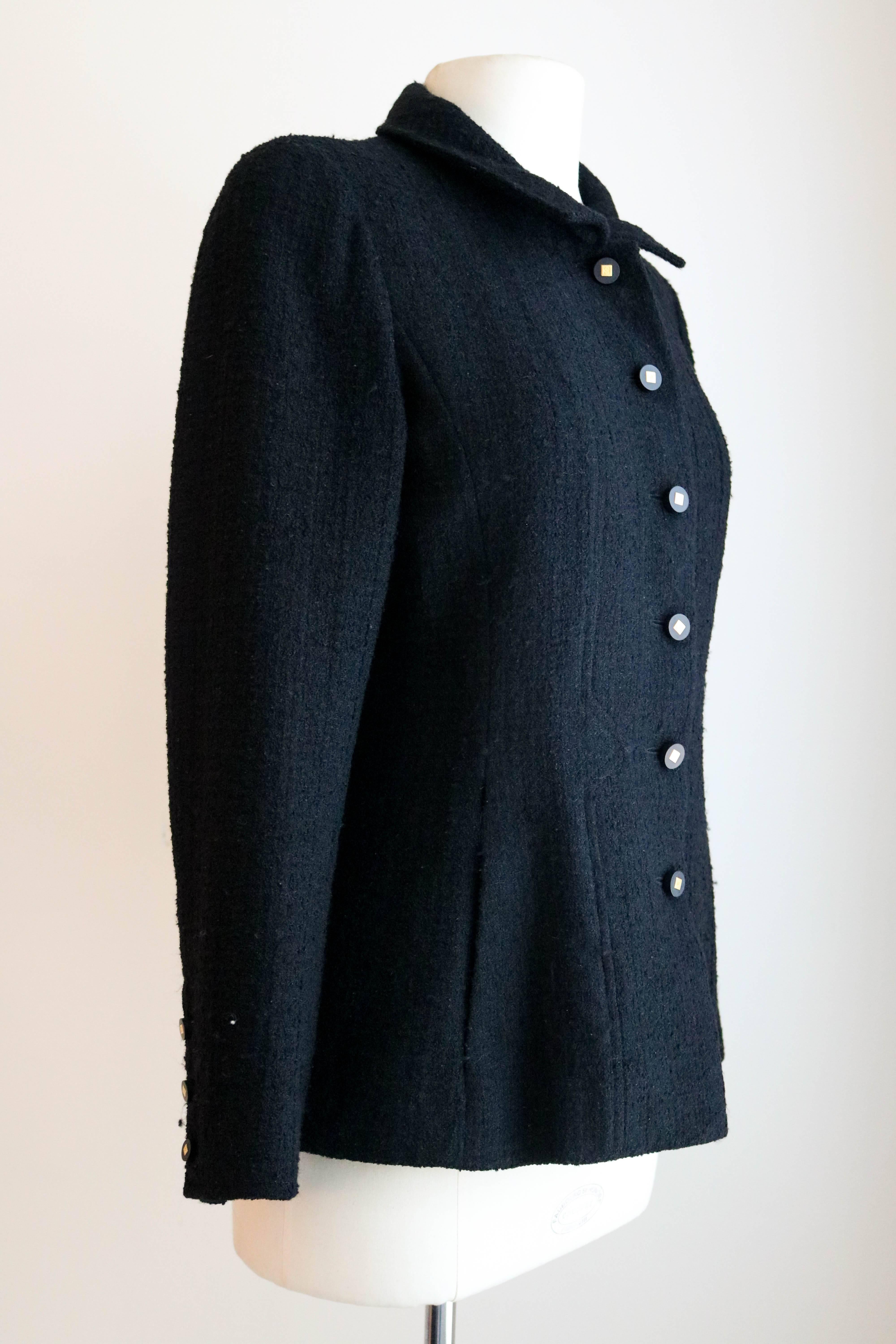 Offered is a Chanel classic black boucle blazer with logo buttons.  Six buttons on front closure and three on the sleeves.  Simple single collar.  Abstract stitch details,  and two slip pockets. Silk lining.  Size based on fit model is 38. 