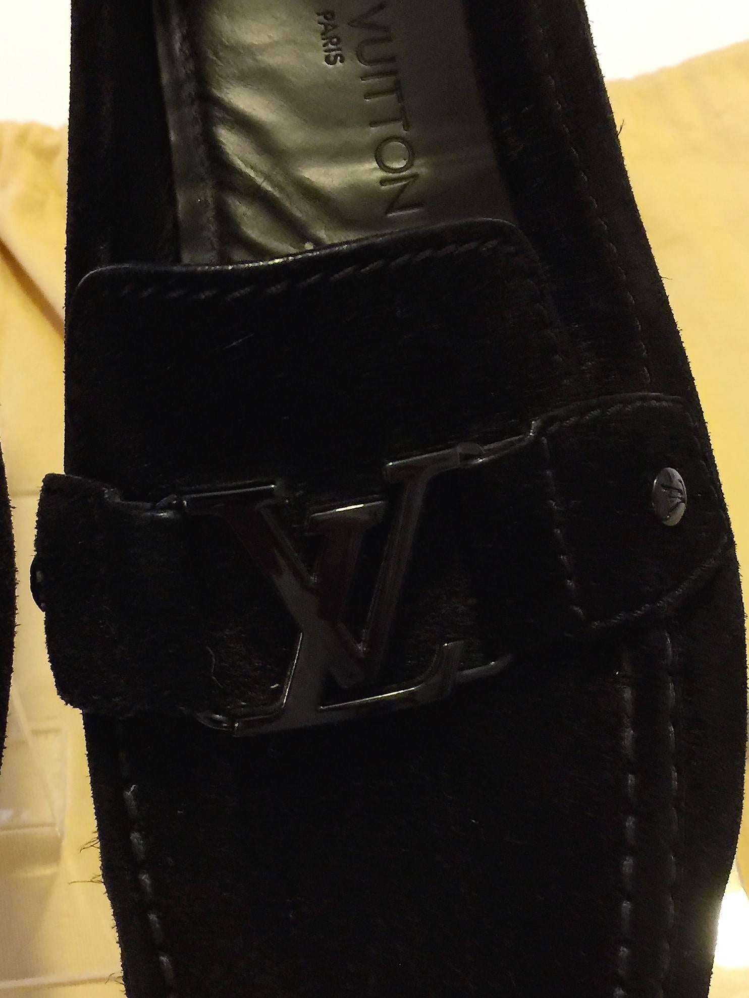 LOUIS VUITTON Men’s Black Suede Monte Carlo Slip-On Moccasin Loafers (Intrepide). These comfortable loafers are made from smooth black suede with leather interior. It is accented with black metal LV buckles, stitched square toes and rubber soles.