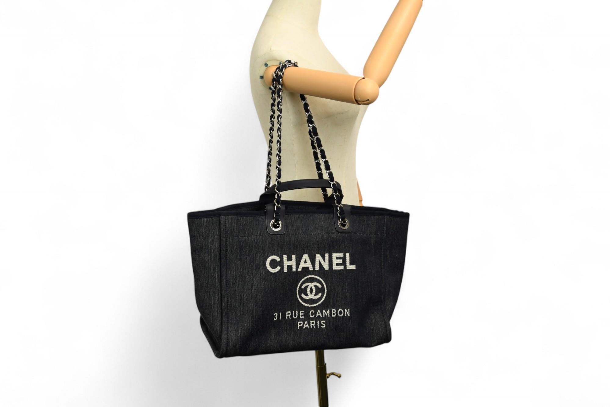 Icône décontractée et luxueuse des collections saisonnières de Chanel, ce fourre-tout Deauville 2014/2015 est confectionné en toile de denim foncé résistante, avec une broderie ivoire audacieuse 