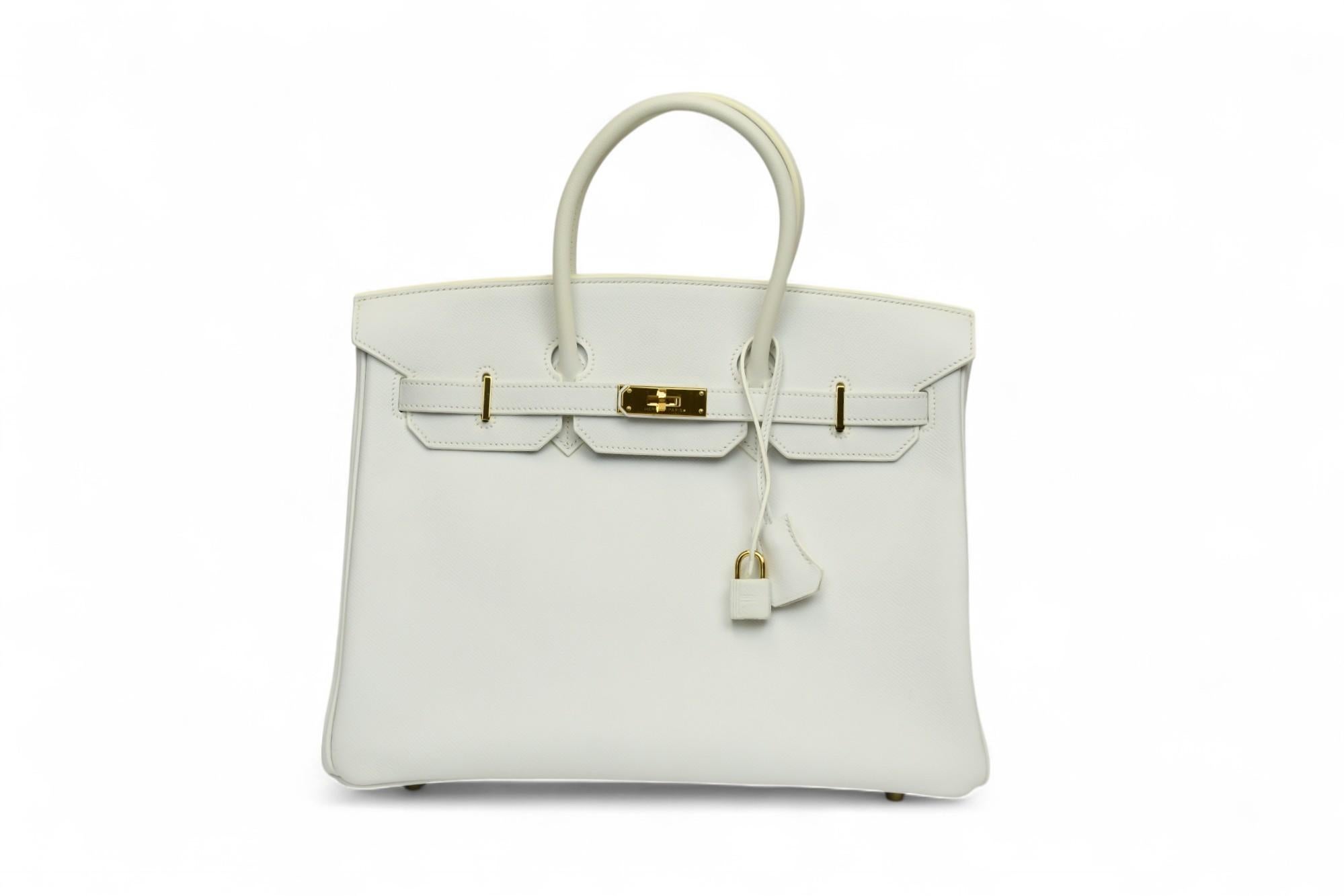 Una gemma rara nel mondo delle borse di lusso, questa Birkin 35 di Hermès del 2008 è realizzata in pelle bianca di Togo. La pelle Togo a grana fine offre una resistenza elastica e una finitura morbidamente strutturata, splendidamente contrastata