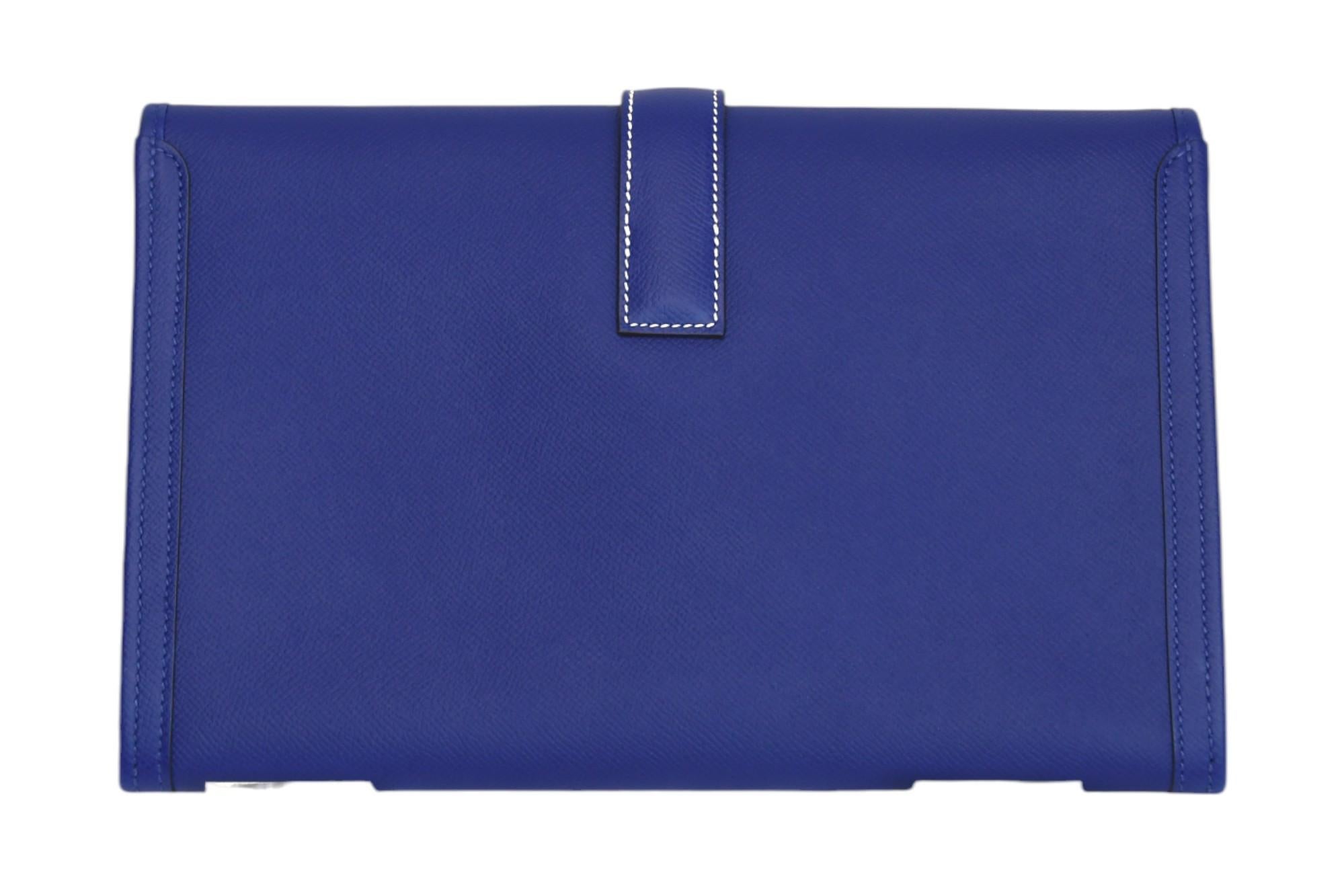 Eleva la tua collezione di accessori con questa straordinaria pochette Hermès Jige, realizzata in pelle Epsom blu vibrante con una silhouette strutturata e una chiusura con linguetta 