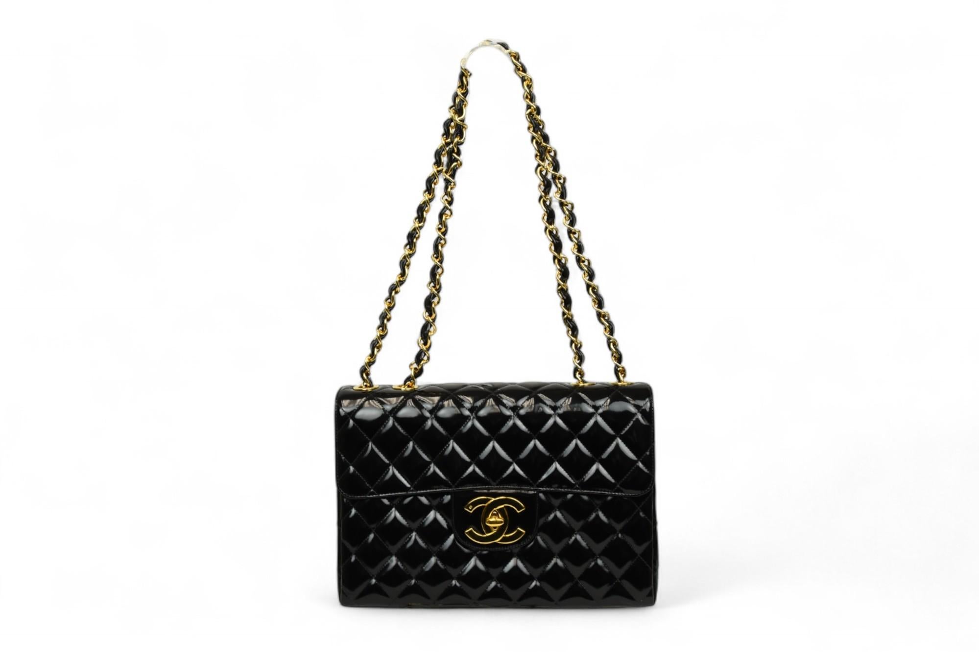 Questa borsa Chanel Jumbo Classic Flap è in vernice nera lucida e sfoggia l'iconica trapuntatura a rombi del marchio e le finiture dorate. La lucentezza che fa da padrona è abbinata a una silhouette generosa, perfetta per essere indossata sia di