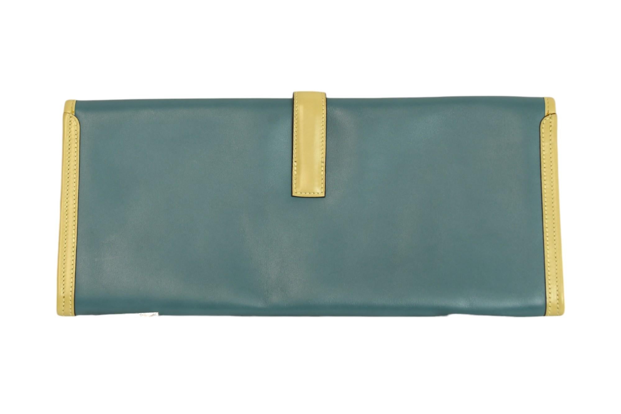 This Hermès Jige Élan 35 clutch is a modern icon, crafted from supple Swift leather in a serene bi-color combination of Bleu Ciel and Parchemin. The elongated silhouette and signature “H” tab closure embody minimalist elegance, while the smooth,