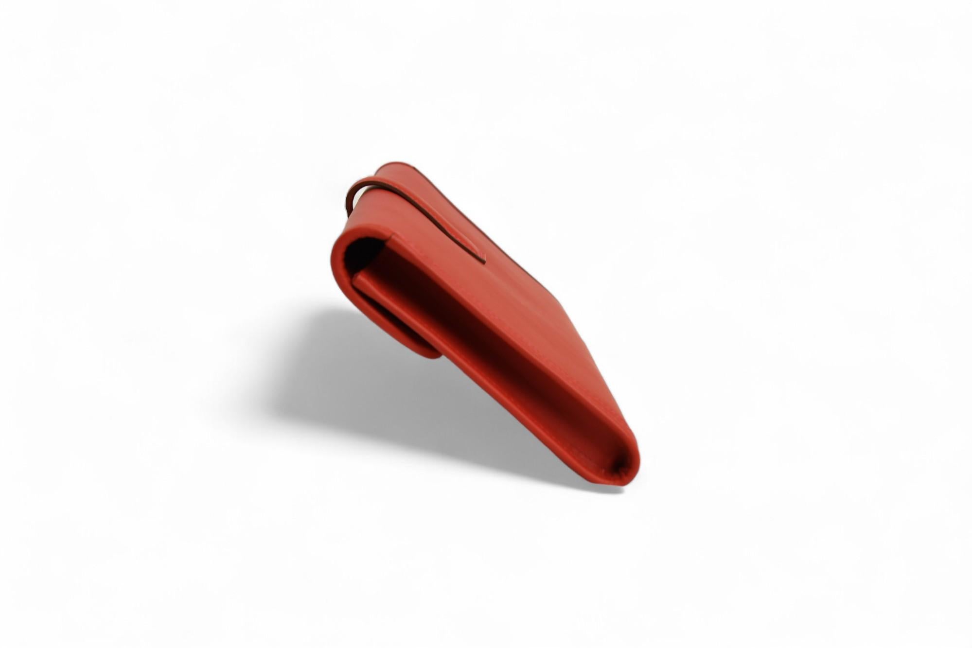 Questa pochette Jige Élan 29 di Hermès è una dichiarazione di eleganza moderna, realizzata in pelle Rouge Casaque con l'iconica chiusura a 