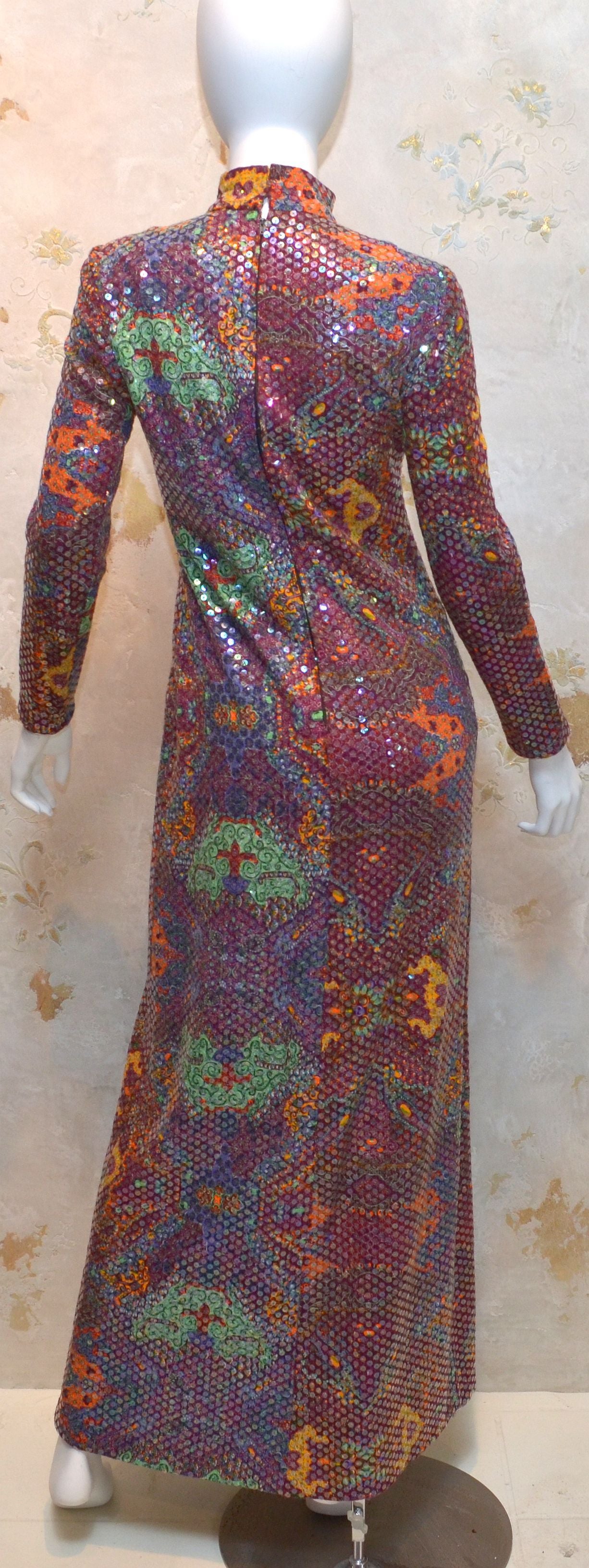 Vintage 1970's Malcom Star Gown features a multi-color Foo Dog print with transparent sequins throughout, back zipper closure, and a mock neck. Dress is fully lined.
 
Measurements: 
Bust - 34''
Sleeves - 23'' 
Shoulders - 15.5''
Waist -