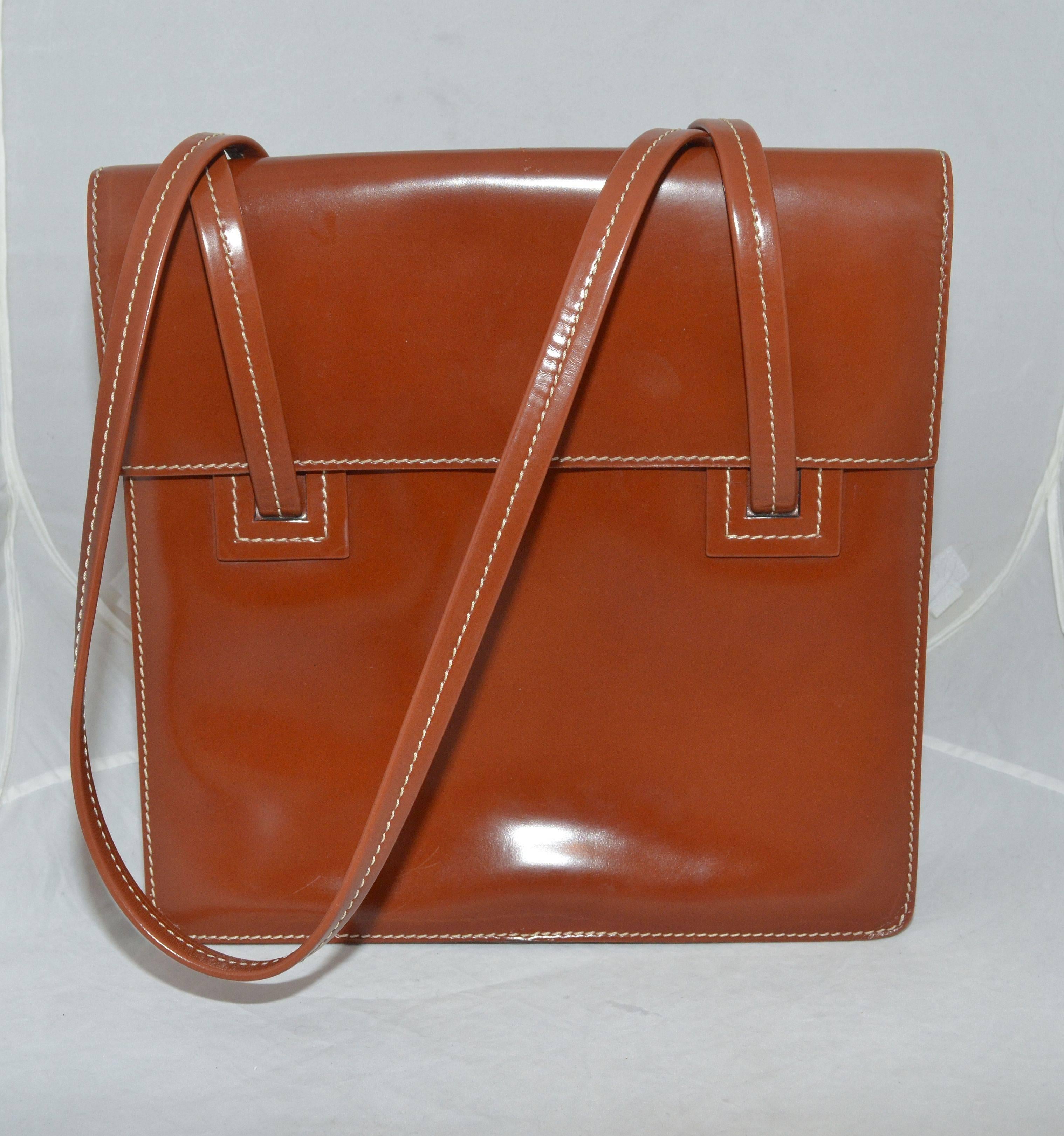 Delvaux Shoulder Bag

Delvaux luxury brand sellier handbag featured in a cognac/brown leather with white top-stitching, flap and snap stud closure, and a full brown suede lining. Interior has one large zipper pocket, a pen slot, and a key ring