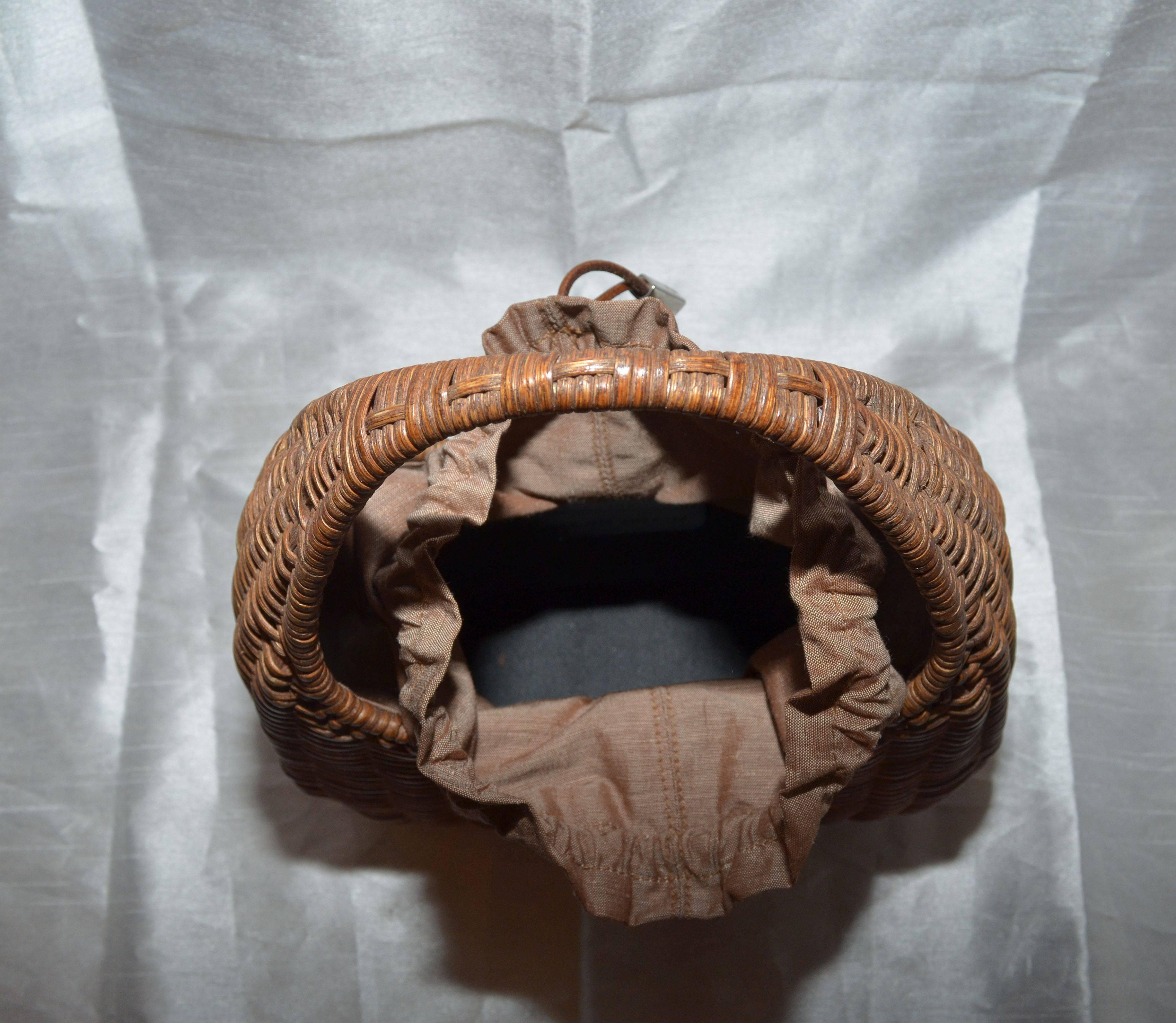 Salvatore Ferragamo Basket Weave Wicker Handbag With Drawstring Closure

Salvatore Ferragamo wicker bag has a nylon cotton blend lining with engraved metal trim drawstring closures at the top and one interior slip pocket. Made in