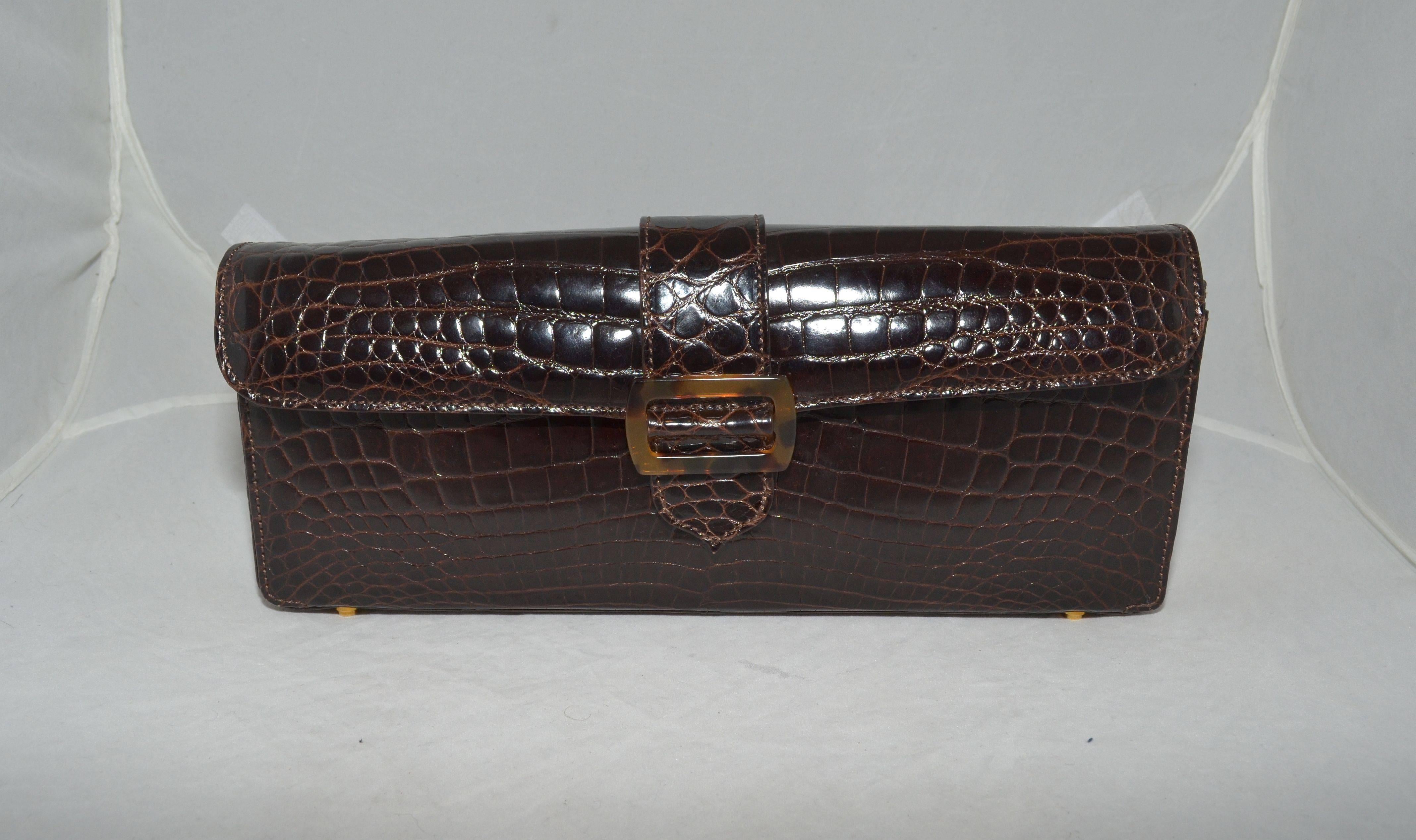 Lana Marks Alligator Clutch with 2 optional Shoulder Straps Tortoise Link and matching alligator Strap Bag

Exquisite Lana Marks clutch is featured in a dark brown alligator skin with a magnetic snap flap closure with a tortoise buckle at the